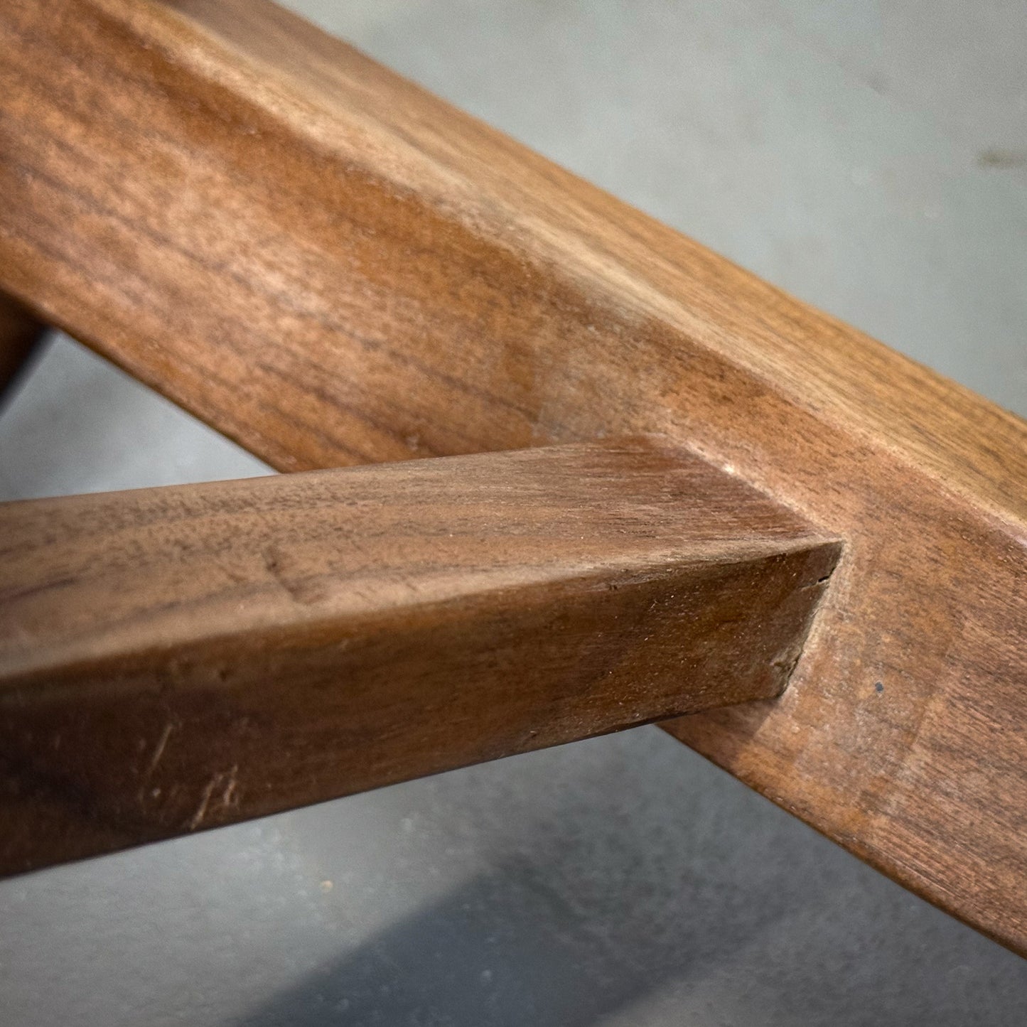 Close-up of a wooden frame with a visible joint on a gray surface