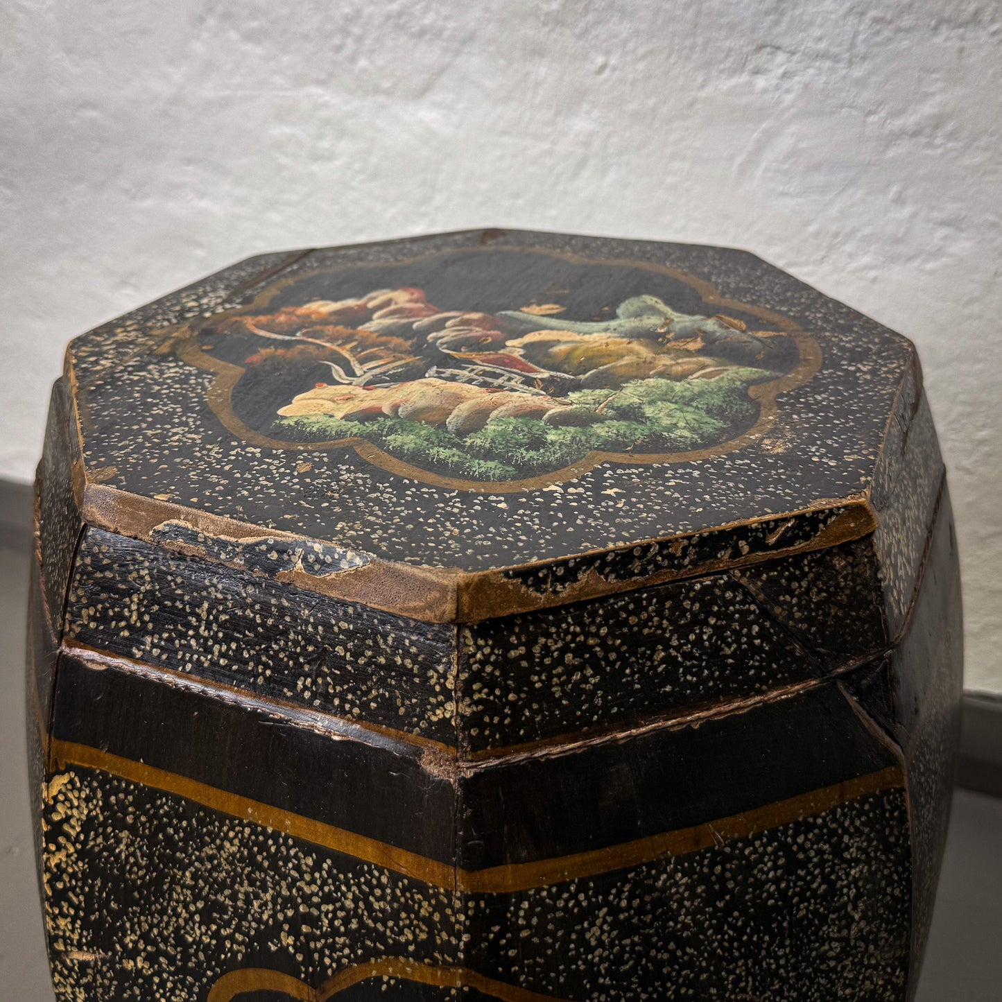 Decorative wooden box with a painted design on a textured white background