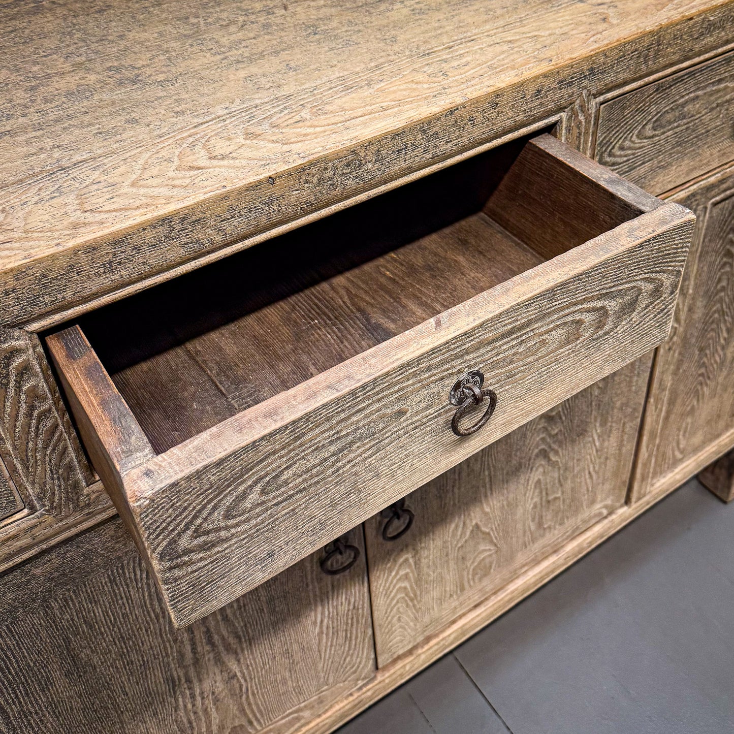 Wooden drawer with a rustic finish on a wooden cabinet.