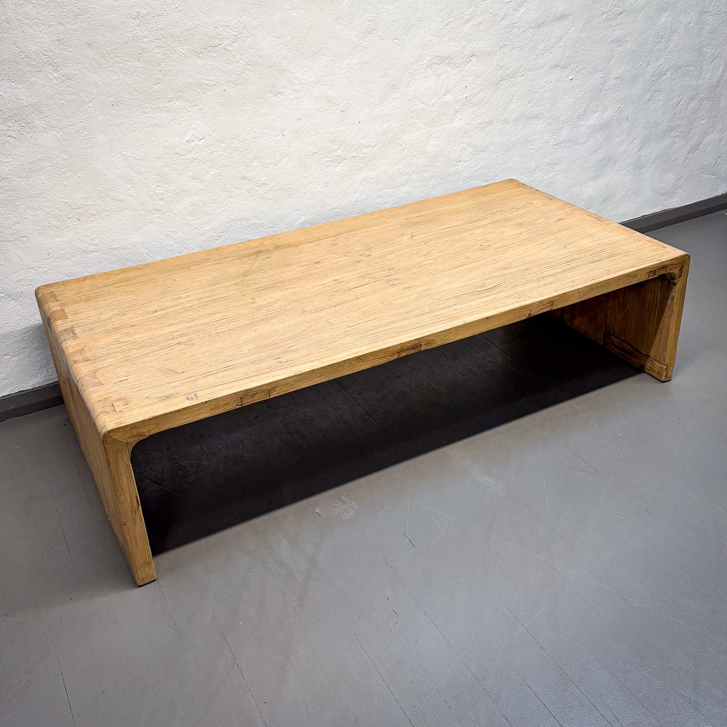 Wooden bench against a plain wall