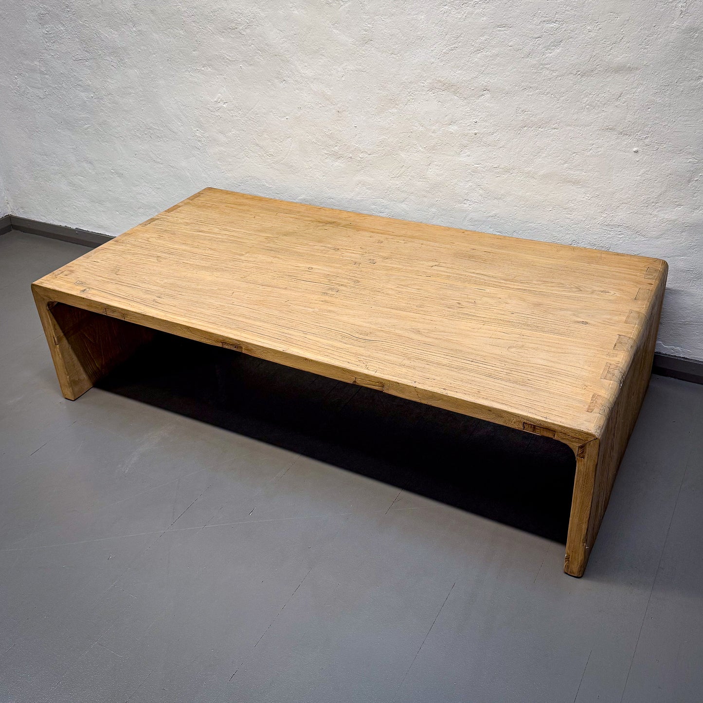 Wooden coffee table against a plain wall