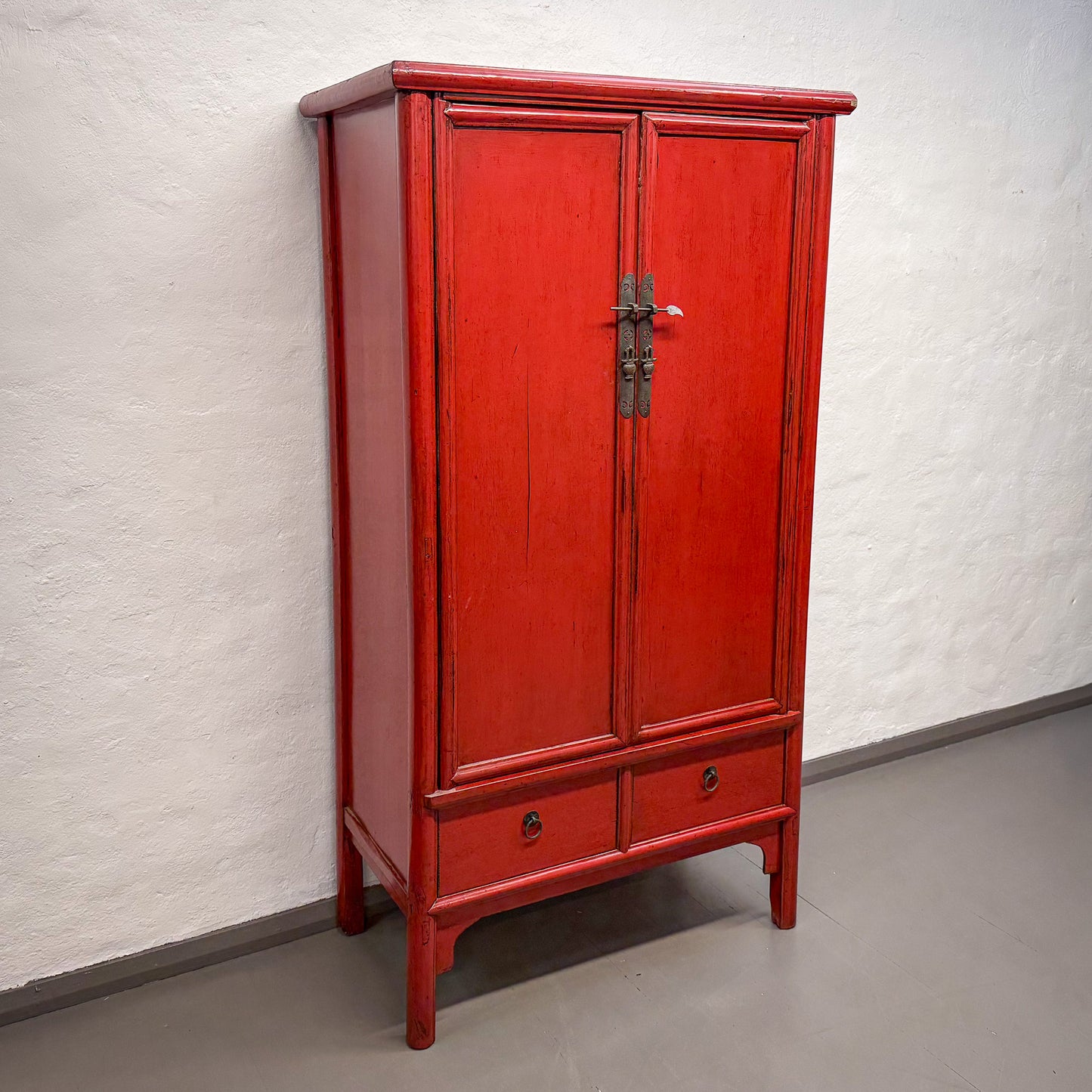 Red wooden cabinet against a white wall
