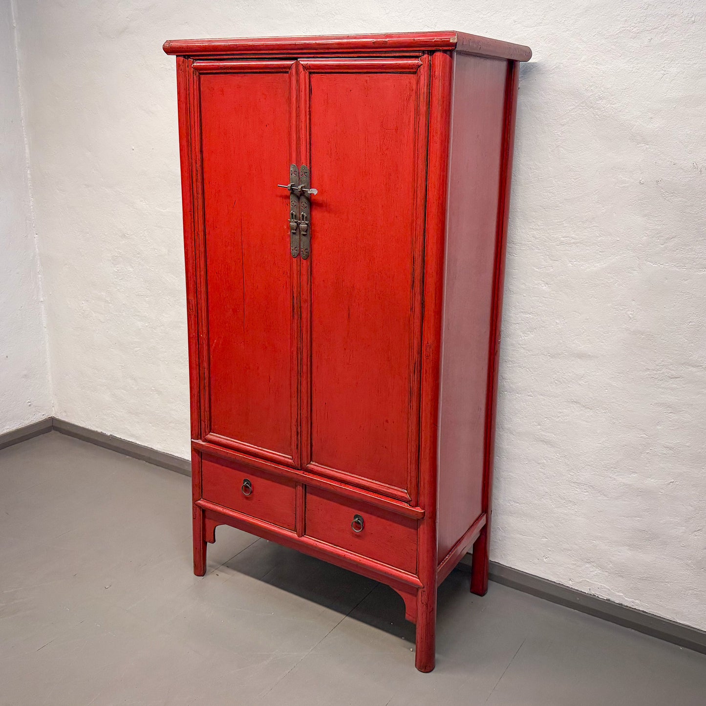 Red wooden cabinet against a white wall