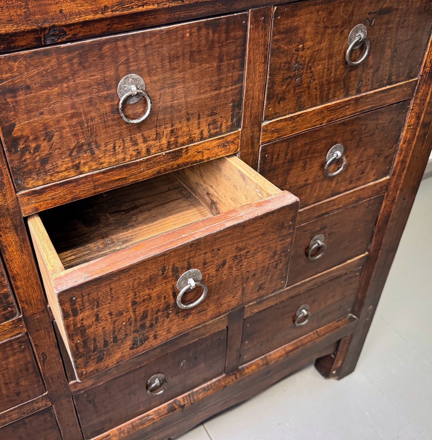 Close-up of an old wooden dresser with open drawer