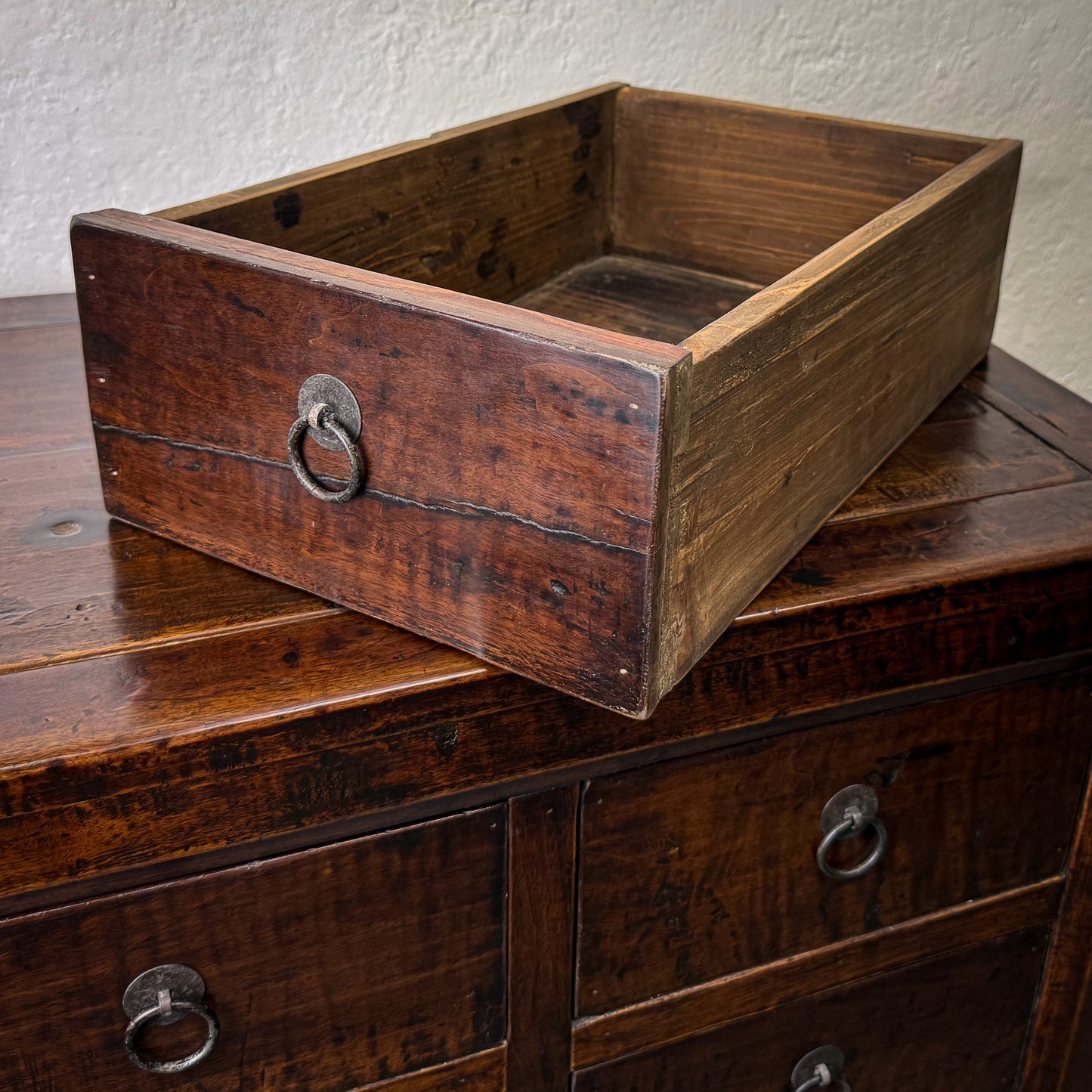 Wooden box on a wooden surface with a textured wall background