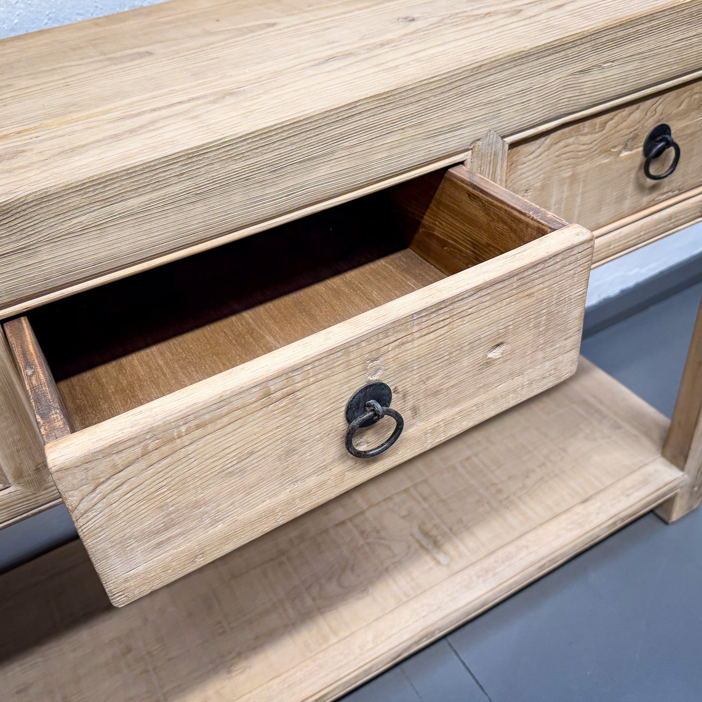 Wooden drawer with a black handle on a wooden cabinet.