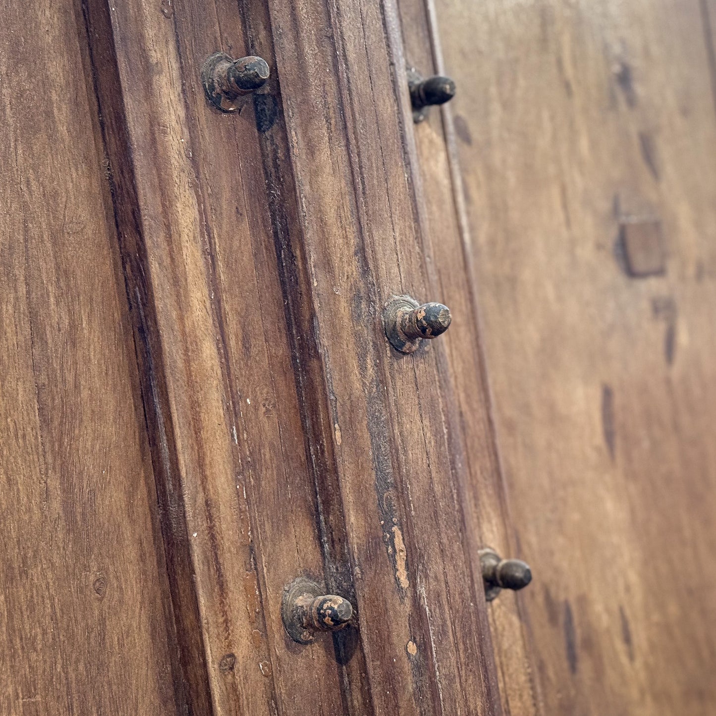 Close-up of a wooden door with metal handles and locks.