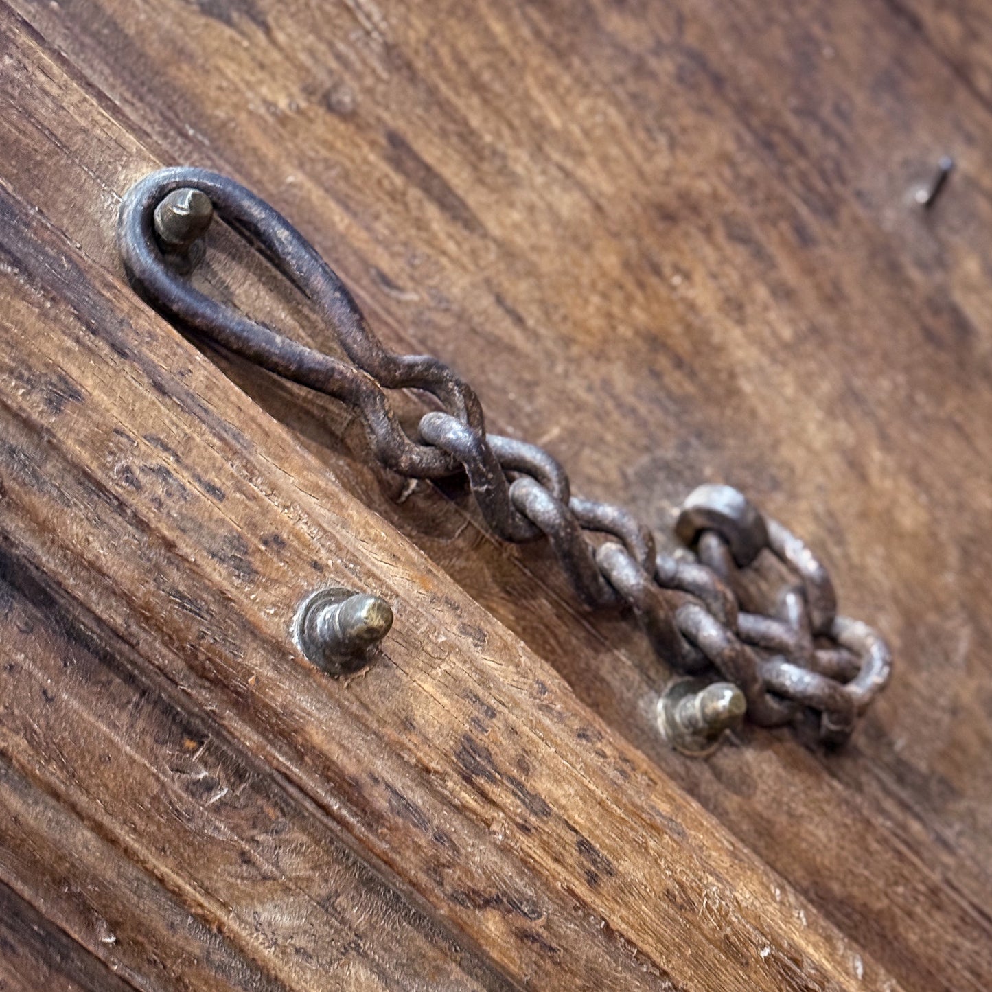 Rustic metal chain and hook on a wooden surface