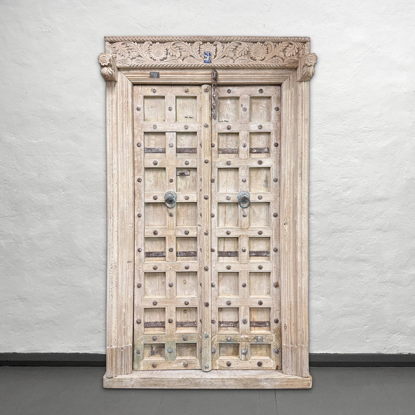 Wooden door with intricate carvings on a plain background