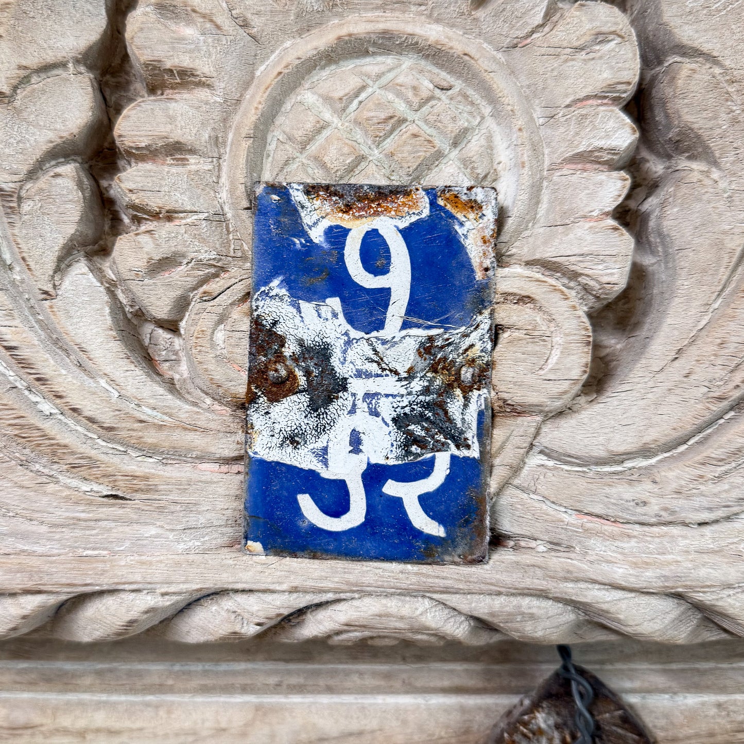 Rustic metal sign with number '9' on a decorative wooden background