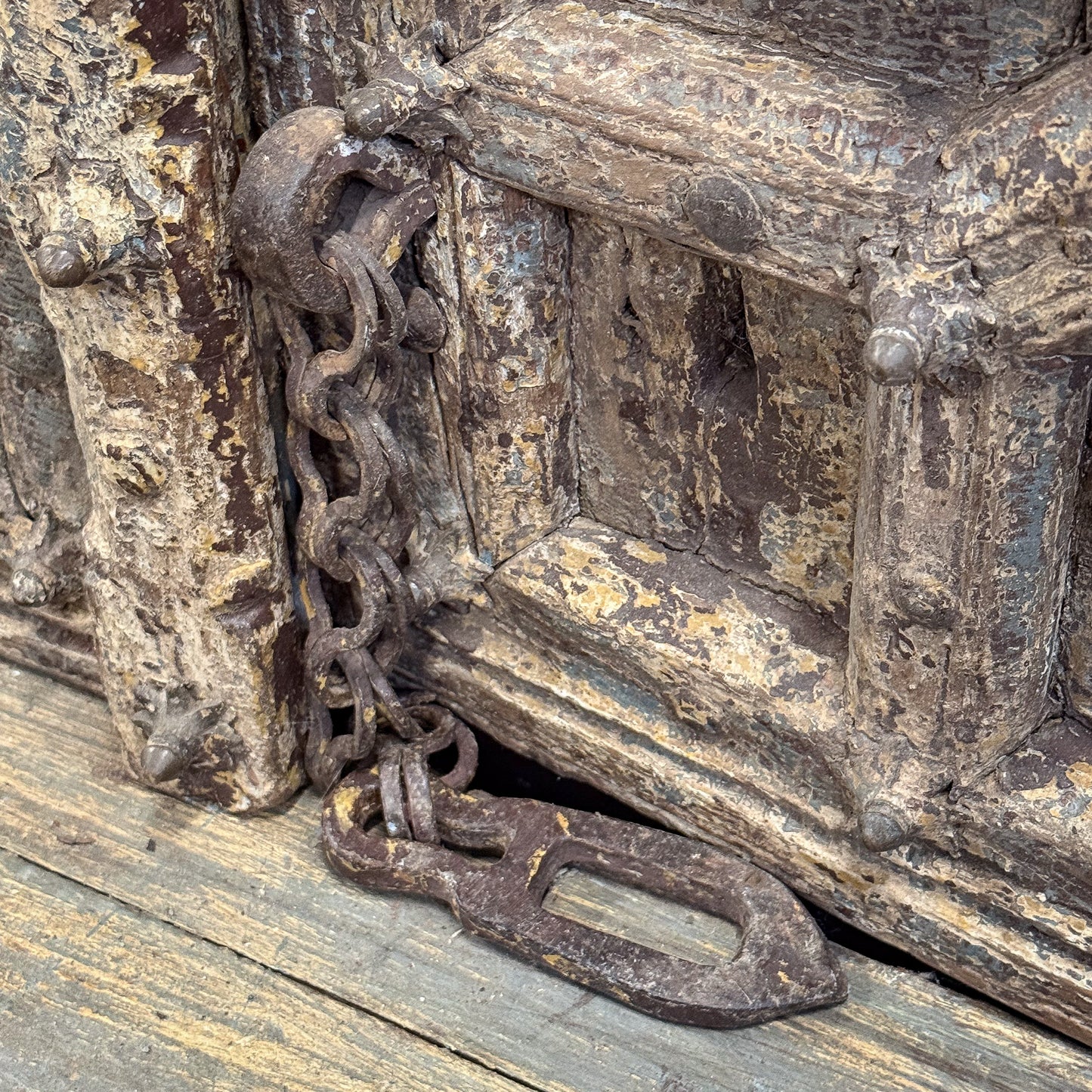 Rust-covered metal chain and lock on a wooden surface