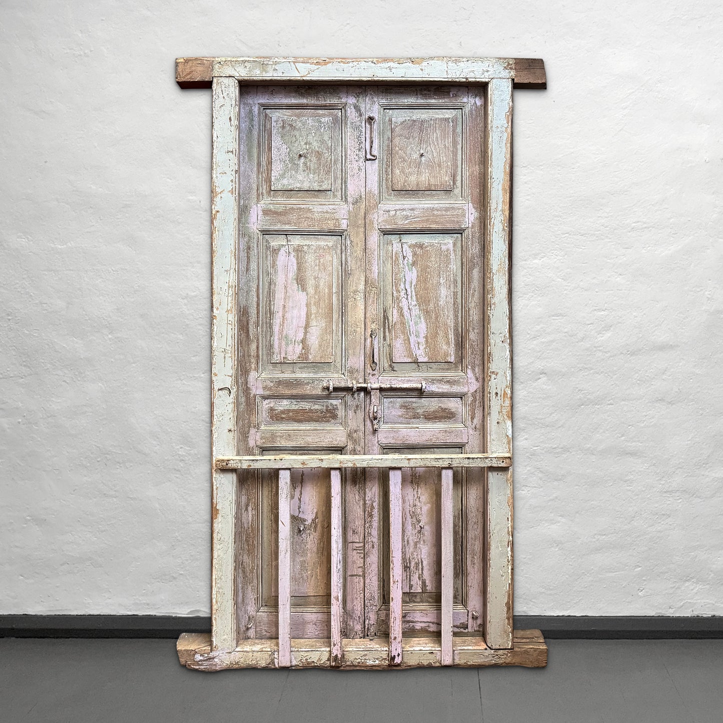 Vintage wooden door with peeling paint on a plain background