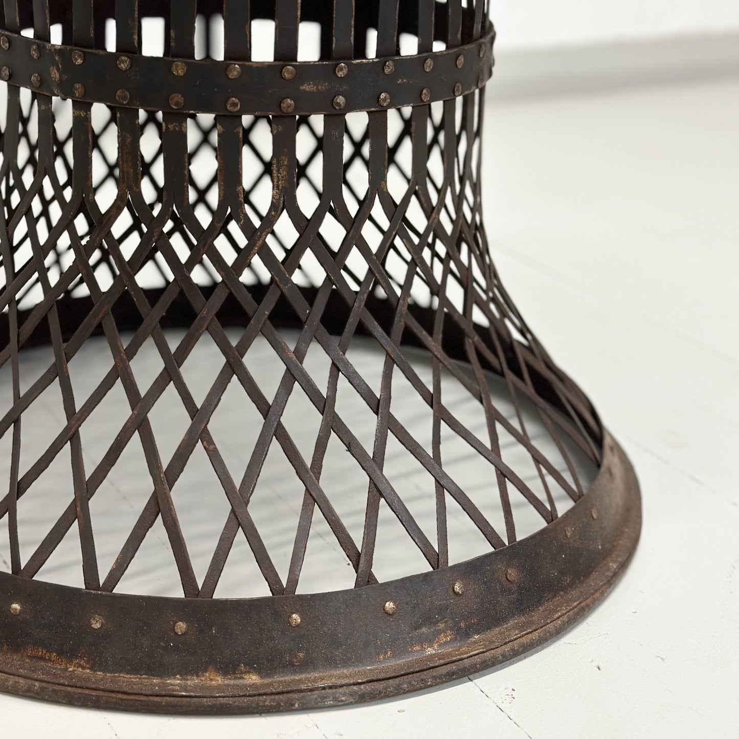 A round iron lattice side table with a dark finish, displayed against a neutral background.