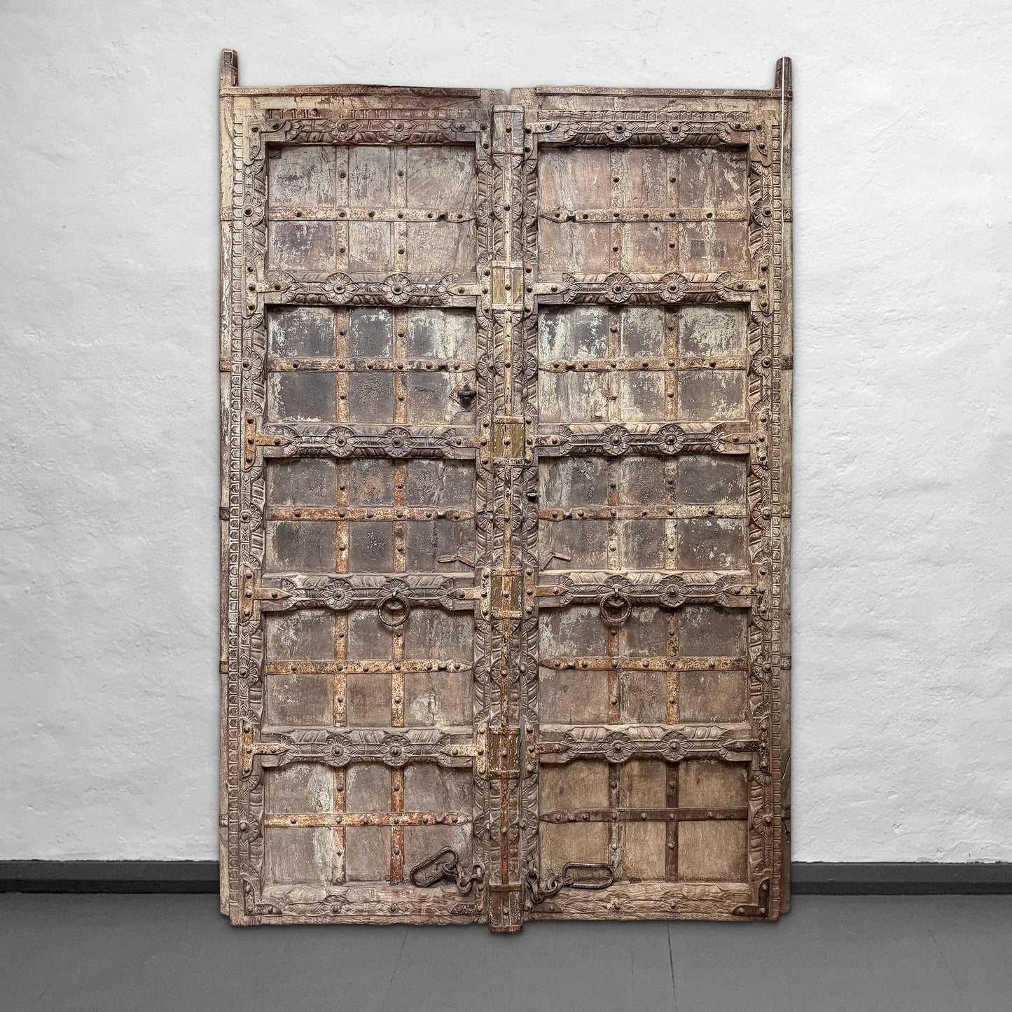 Large ornate wooden door against a plain wall