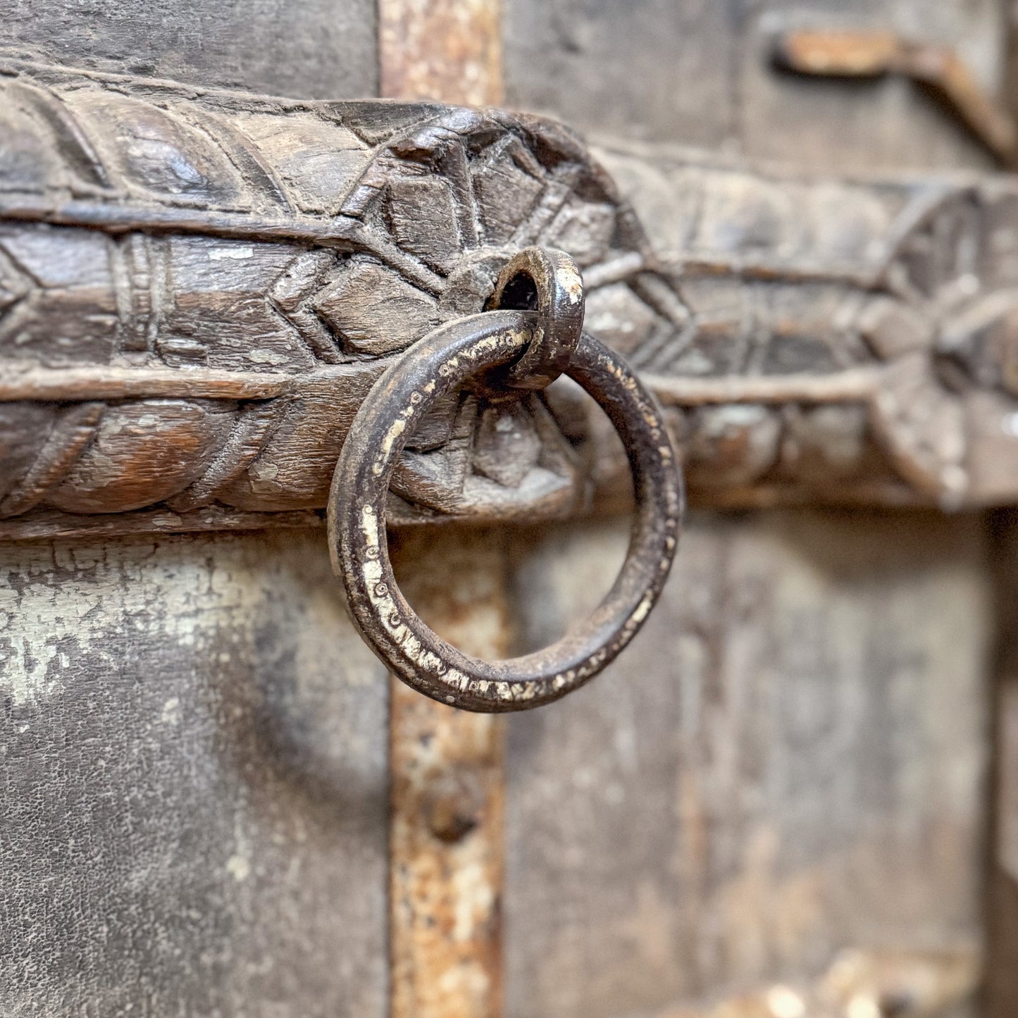 Decorative metal handle on an ornate wooden door