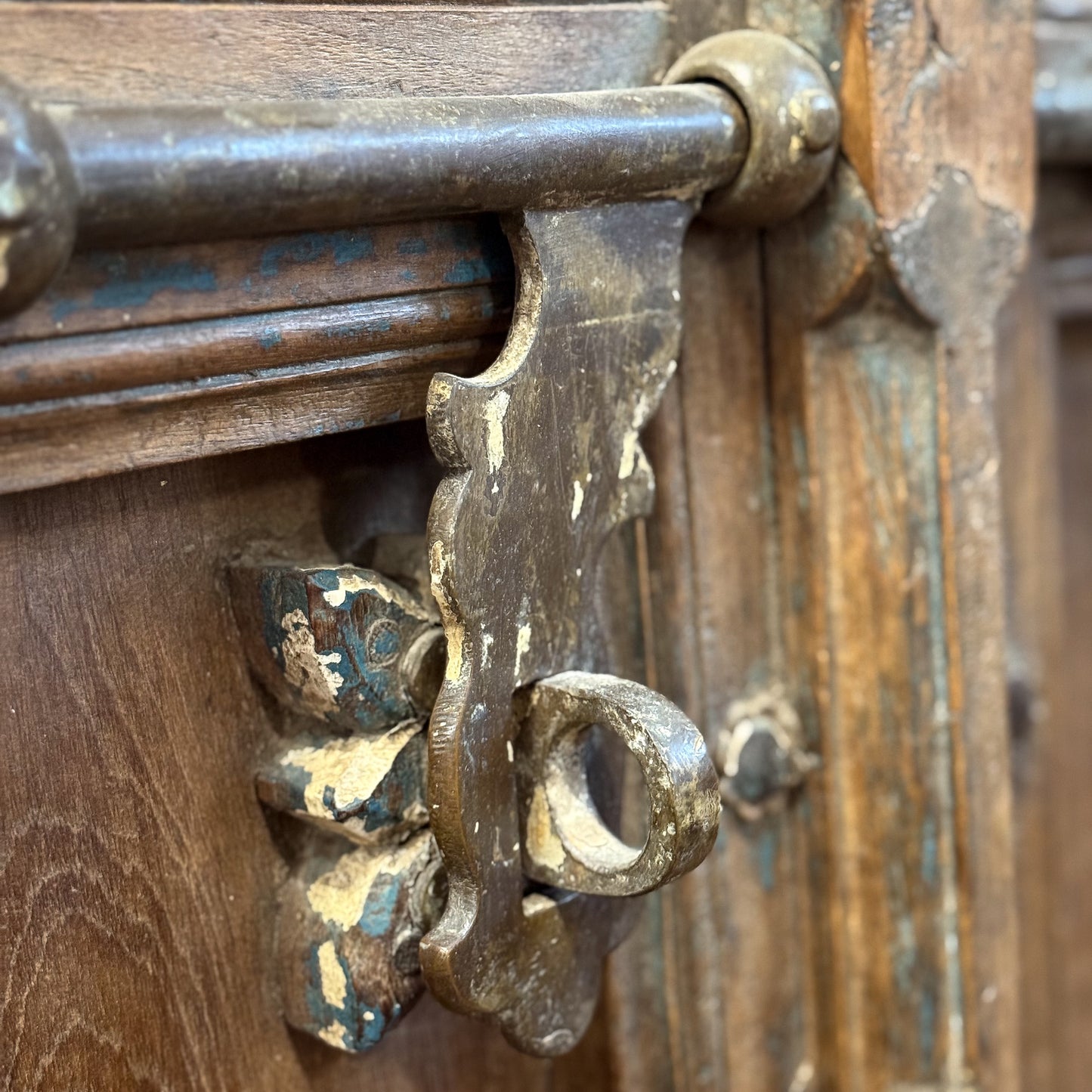 Close-up of an ornate metal latch on a wooden door