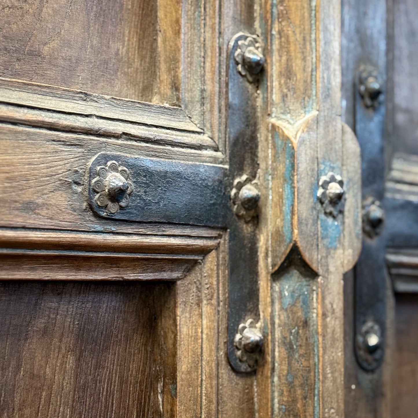 Close-up of an ornate wooden door with metal hardware