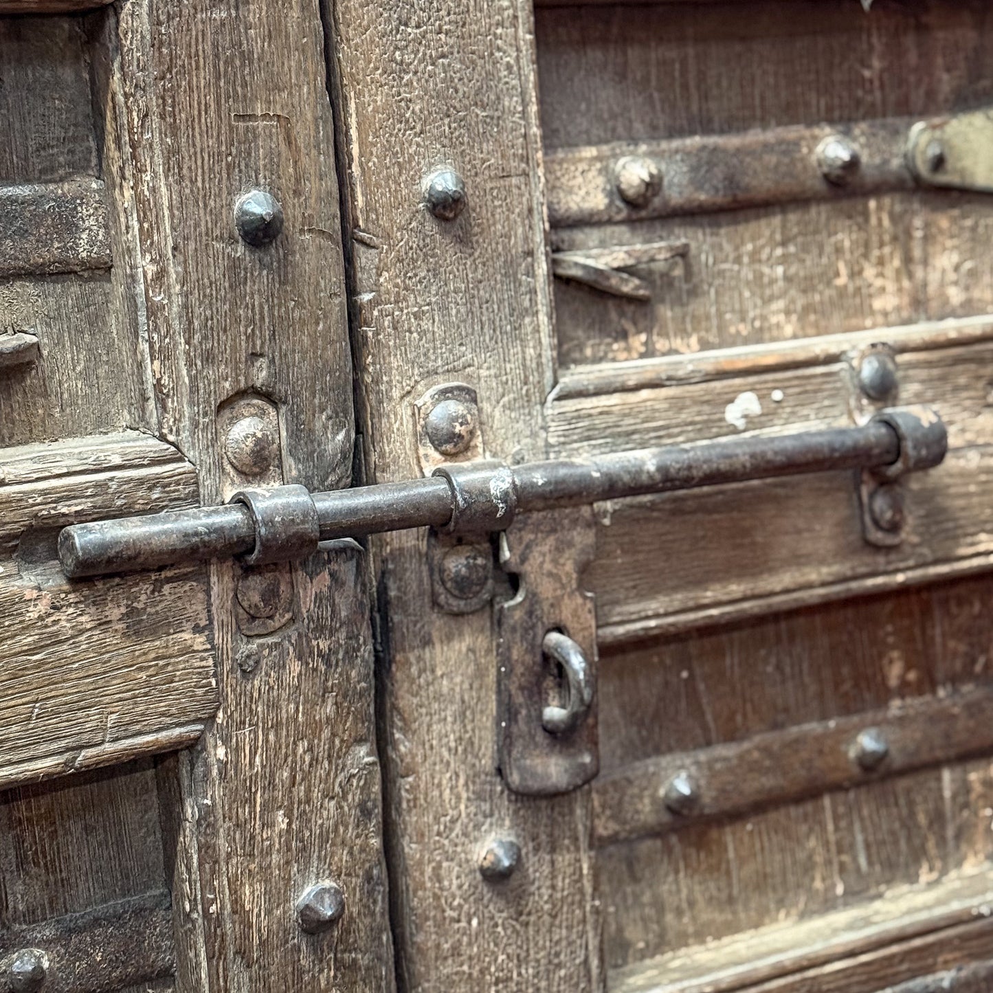 Close-up of a wooden door with metal hardware