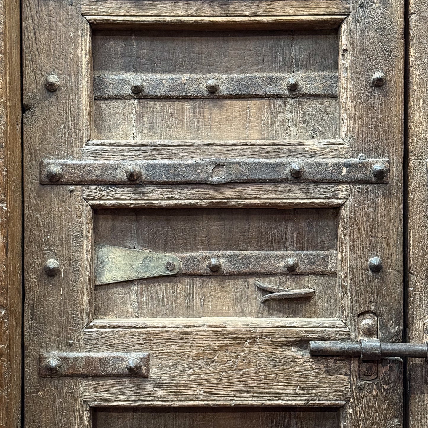 Close-up of an old wooden door with metal hardware