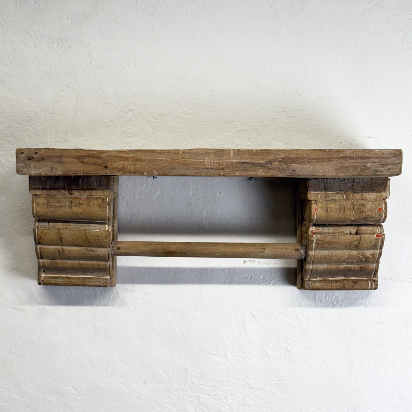 Wooden shelf against a white wall