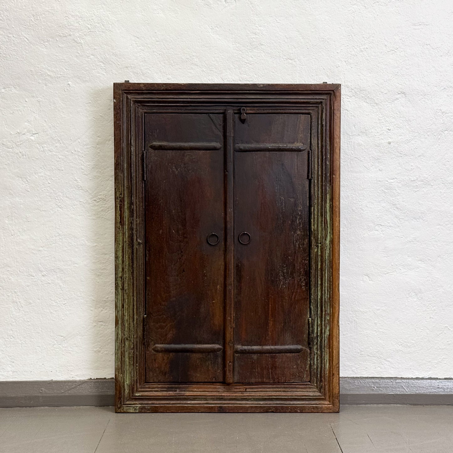 Vintage wooden wardrobe against a white brick wall