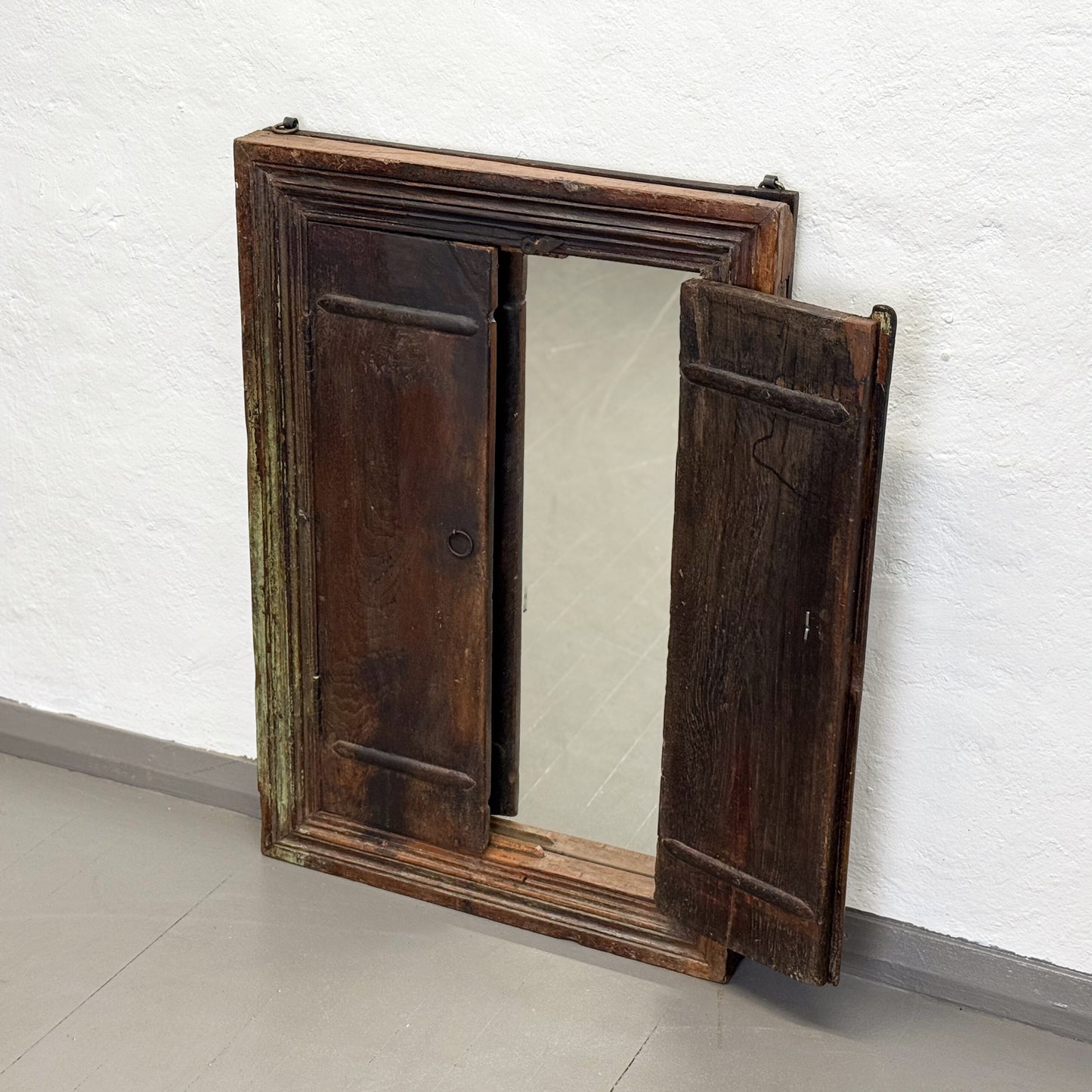 Wooden cabinet with a mirror on a white wall
