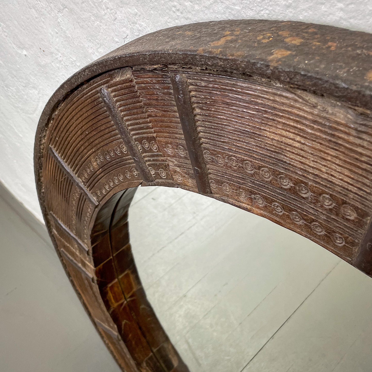 Close-up of a wooden mirror with intricate carvings on a white background