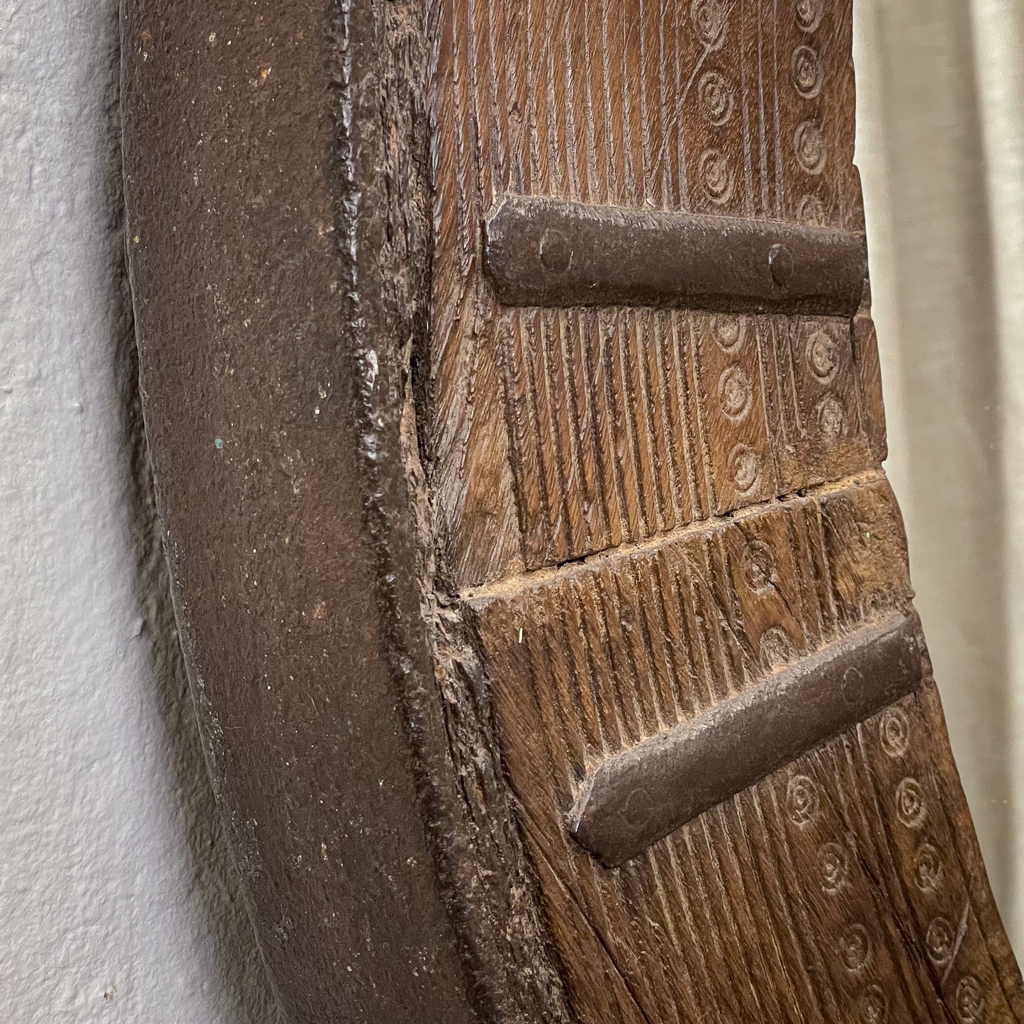 Close-up of a wooden door with intricate carvings and metal fixtures.