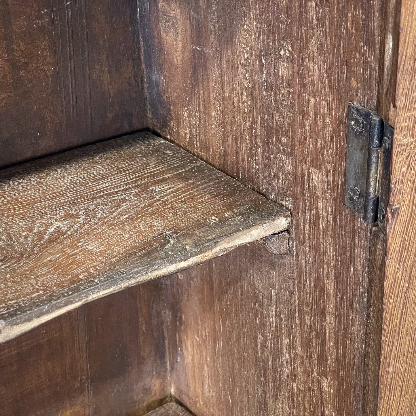 Close-up of a wooden door with a metal hinge