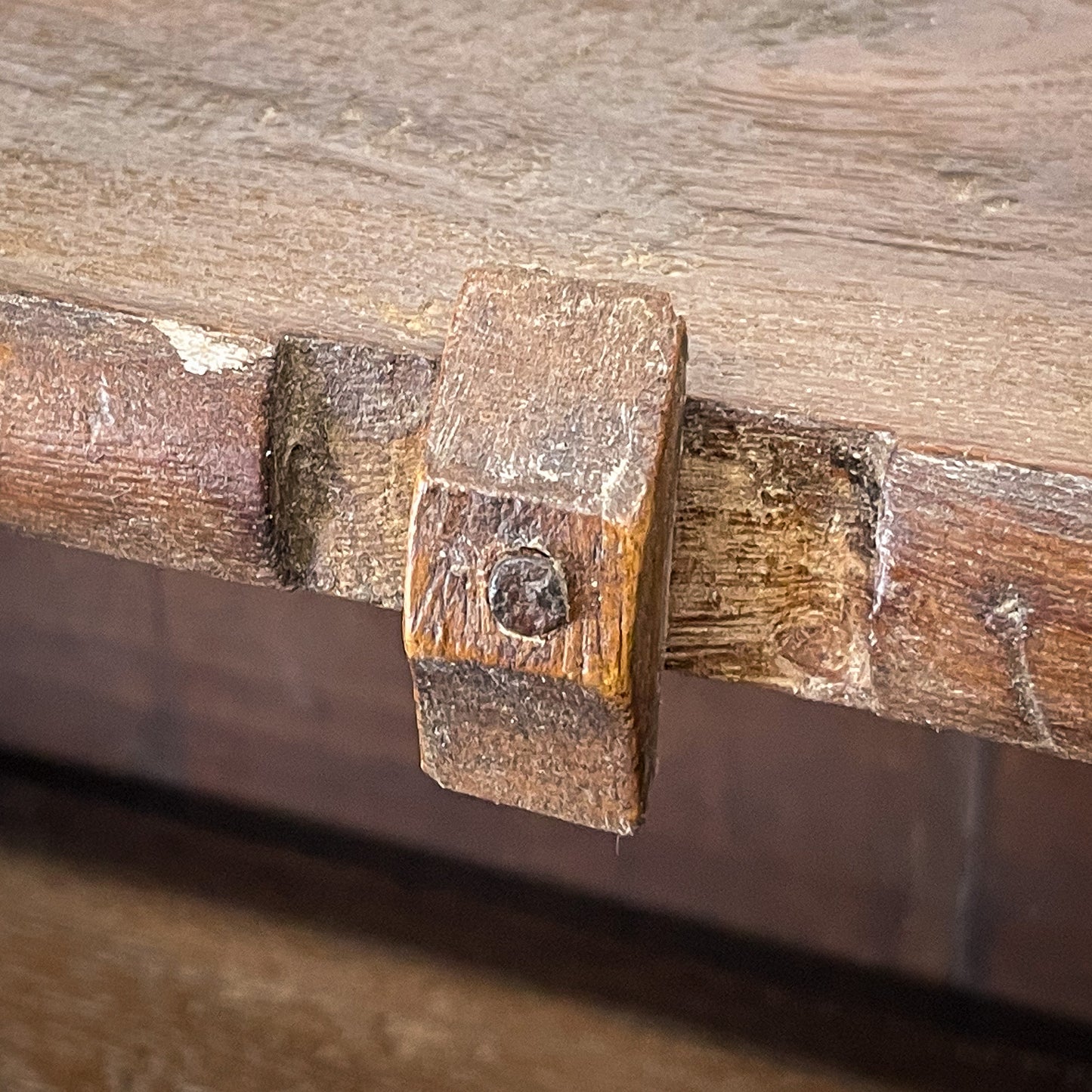 Close-up of a wooden handle with metal fitting on a wooden surface