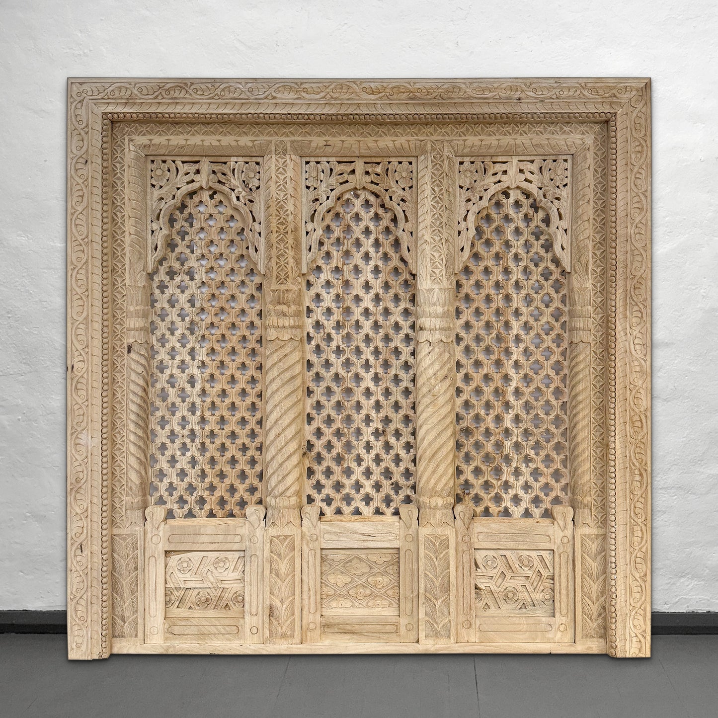 Carved wooden panel with intricate patterns on a plain background