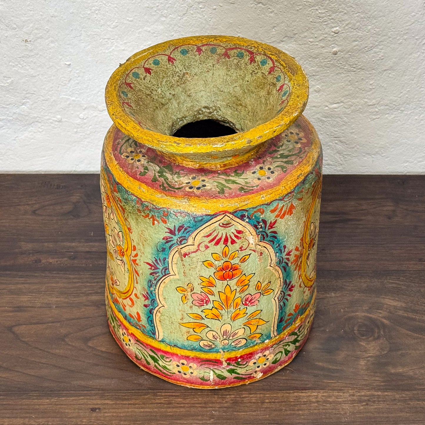 Decorative vase with floral patterns on a wooden surface
