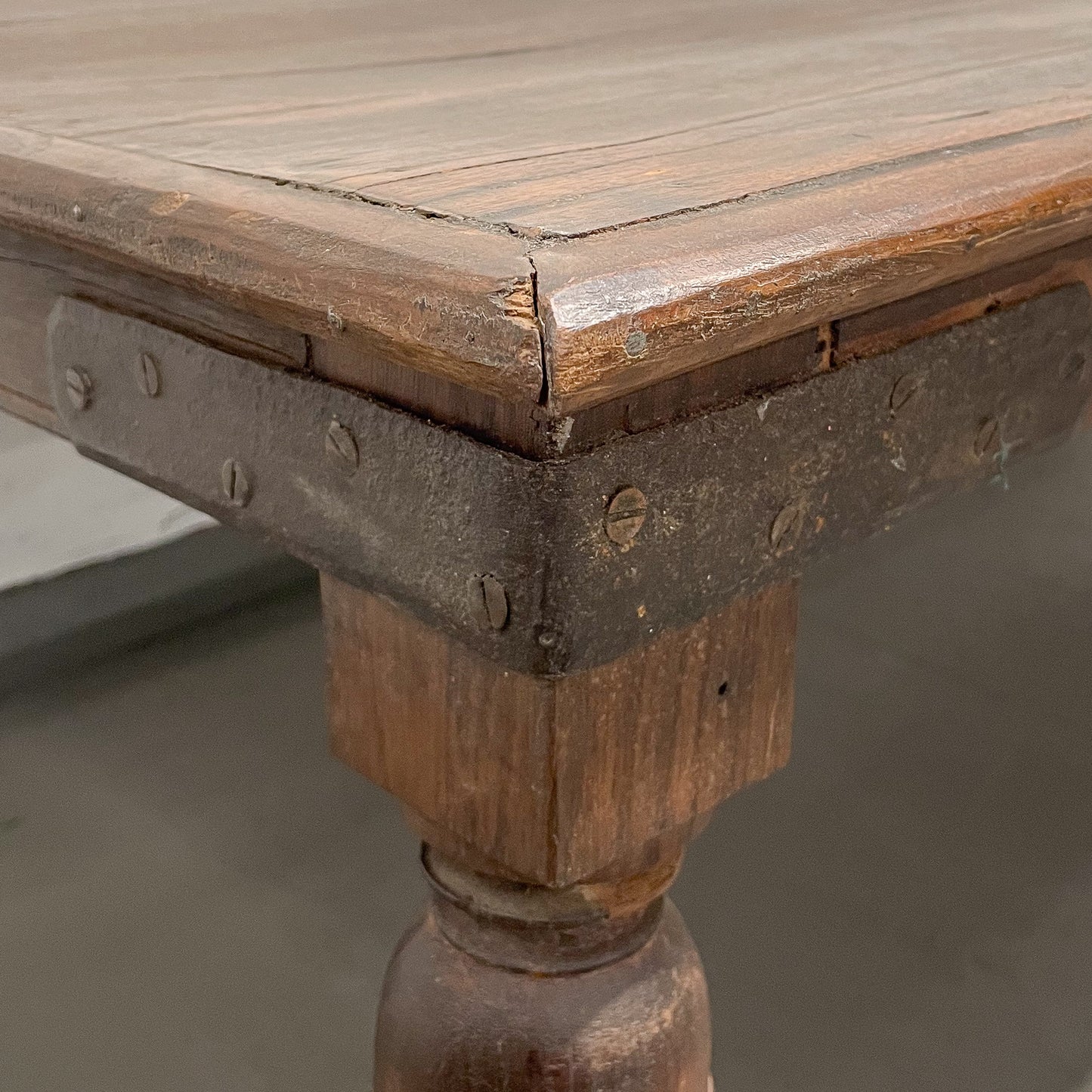 Close-up of a wooden table with metal legs on a gray background