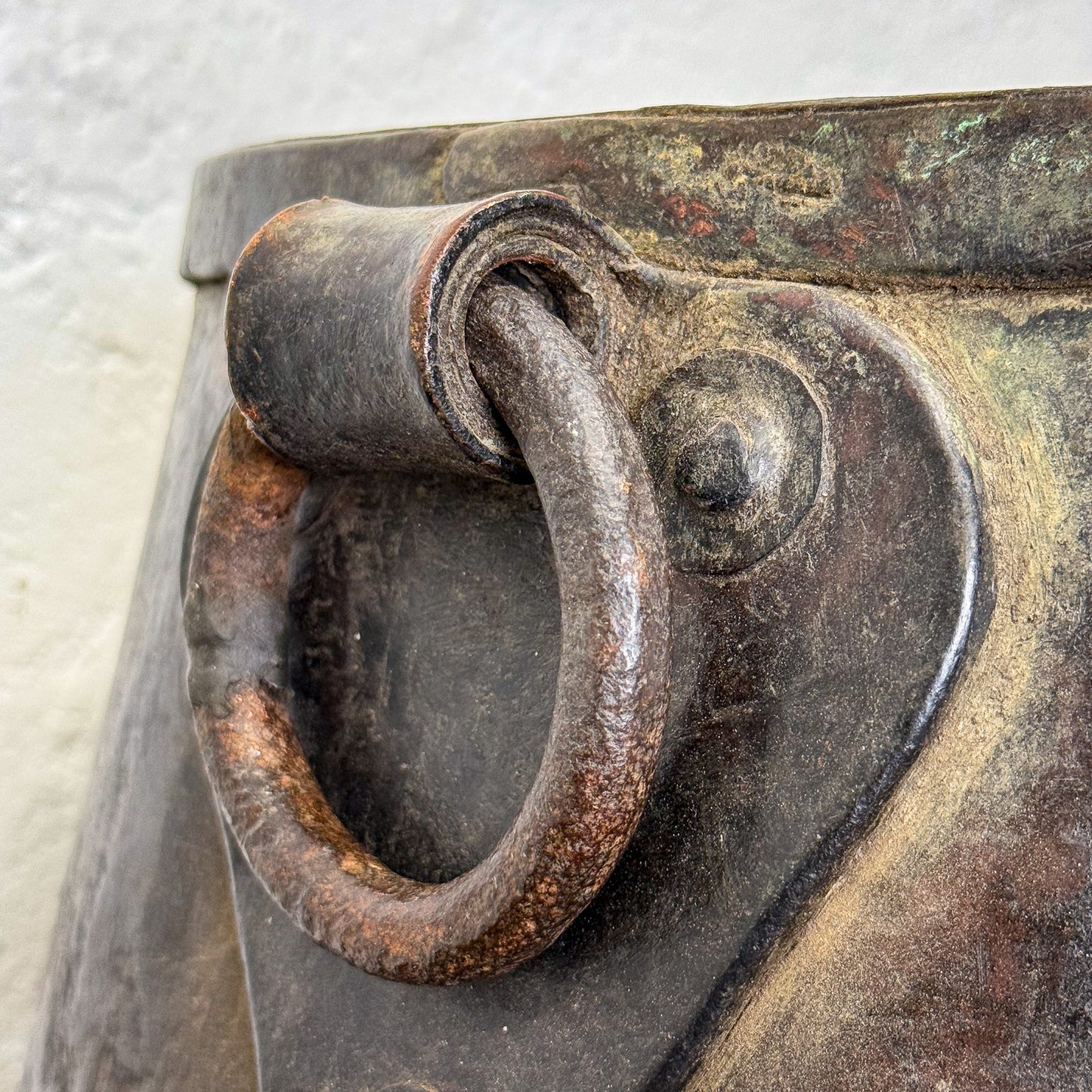 Close-up of a rusty metal handle on a metallic surface