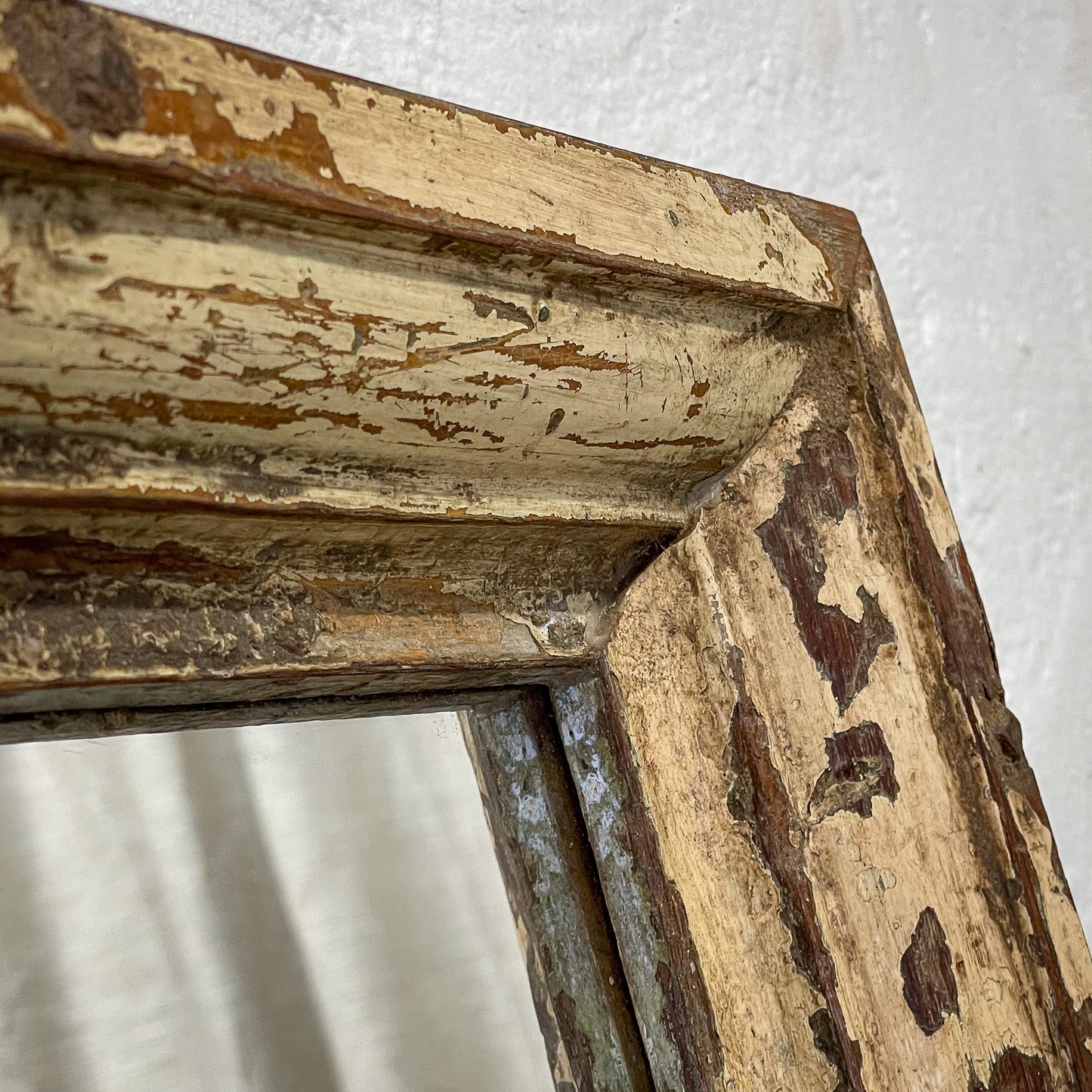 Close-up of an aged wooden frame with peeling paint on a white background