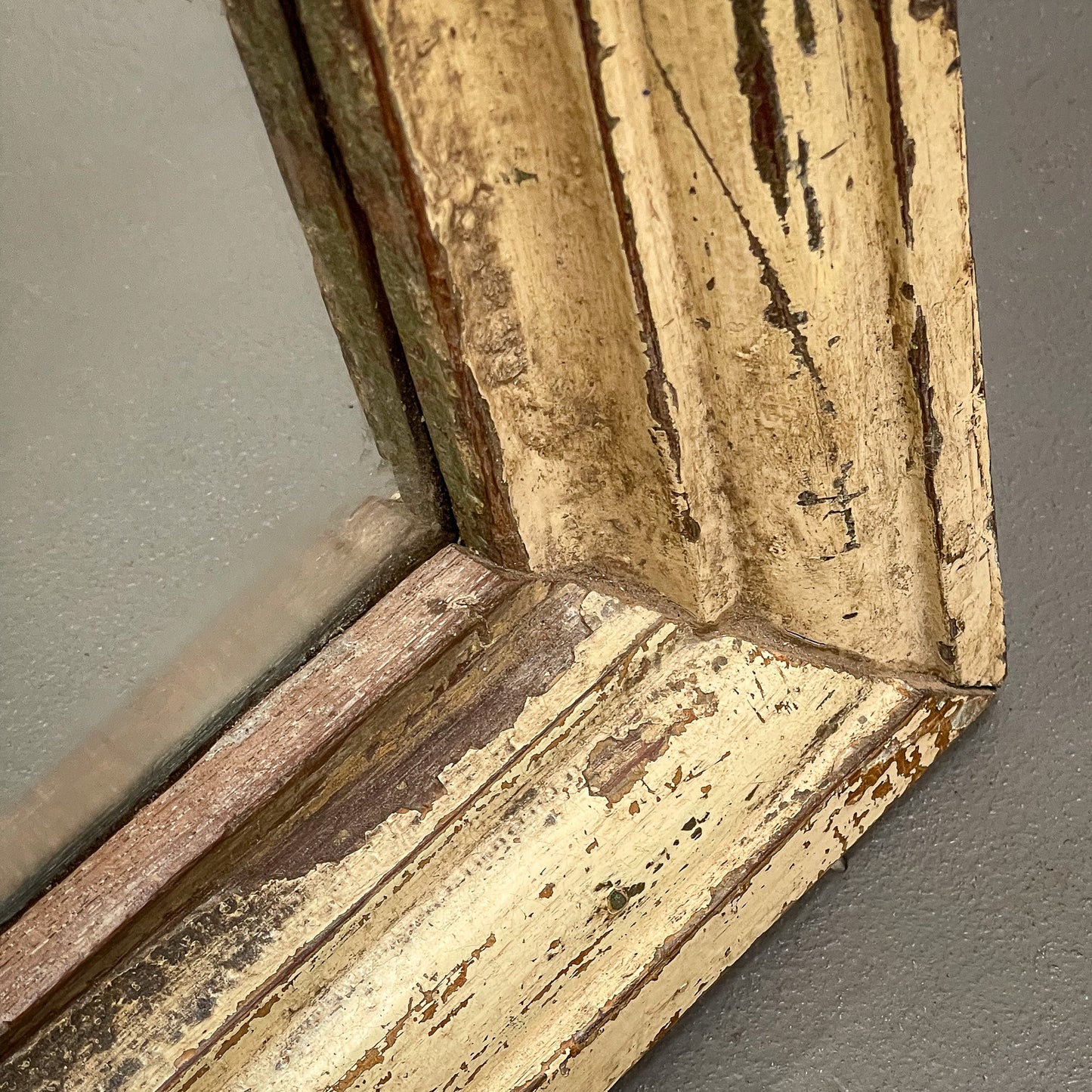 Close-up of an ornate, weathered wooden frame corner.