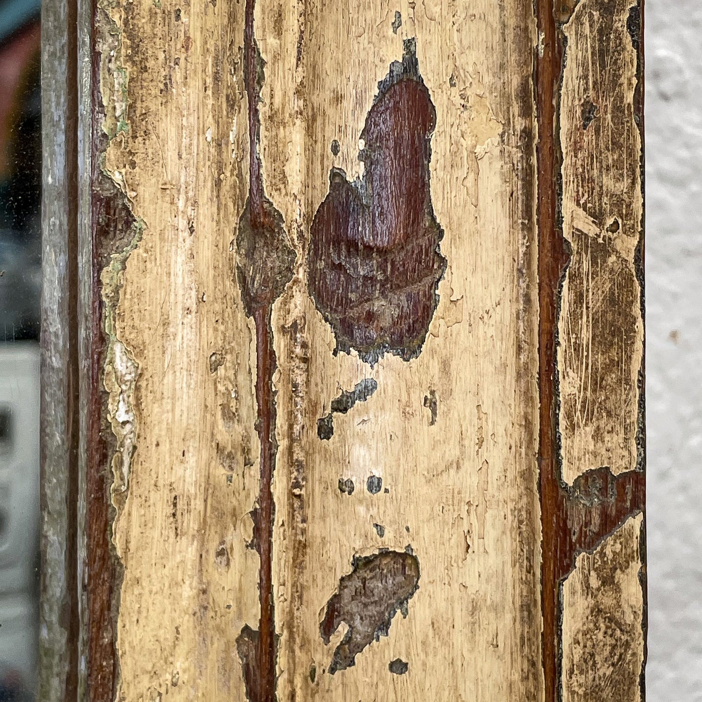 Close-up of a wooden surface with visible grain and patches of dark brown
