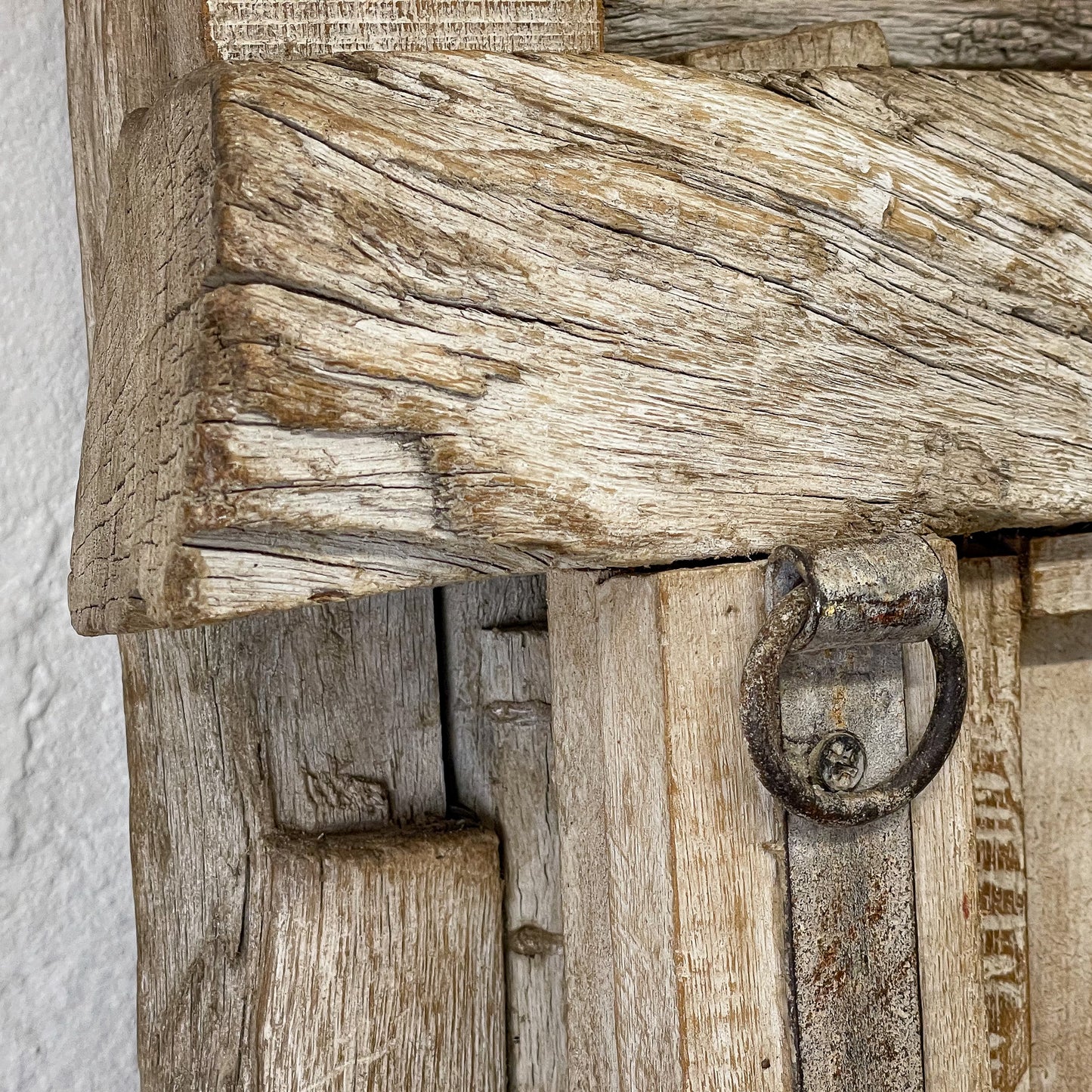 Close-up of a rustic wooden door with a metal handle.