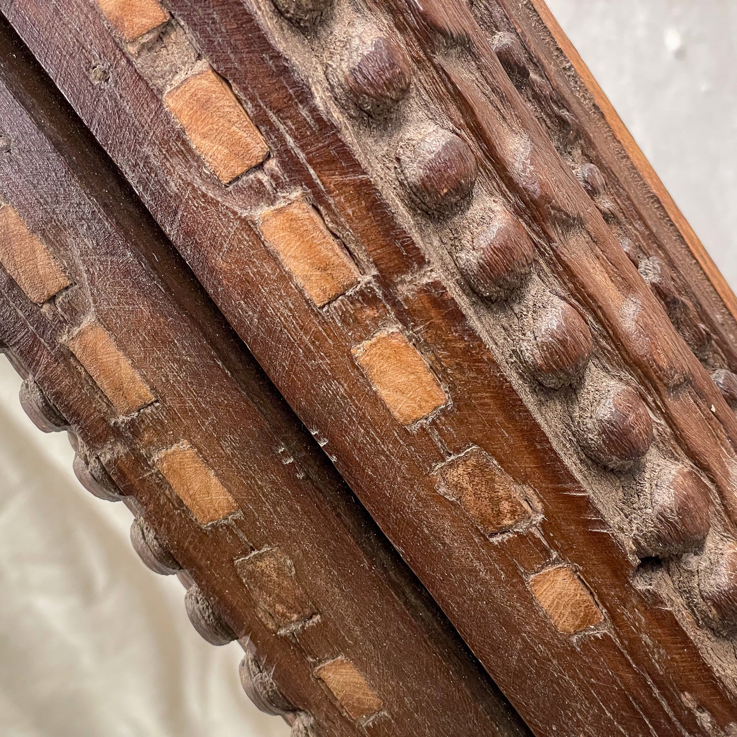Close-up of wooden carvings with intricate patterns on a white background