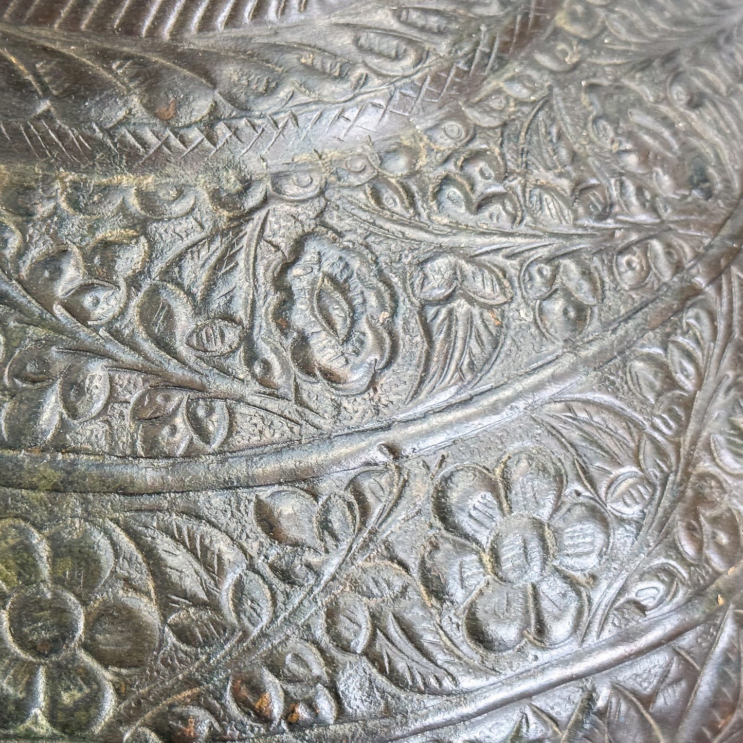 Close-up of an intricately engraved metal surface with floral patterns