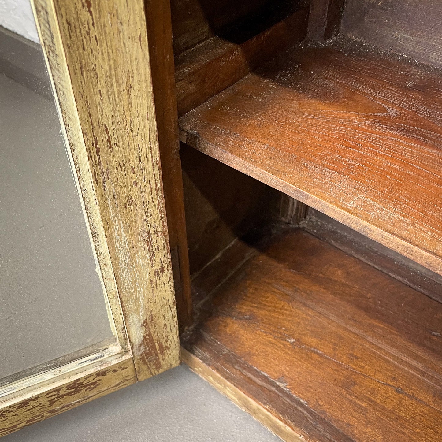 Wooden shelf with a mirror on a gray surface