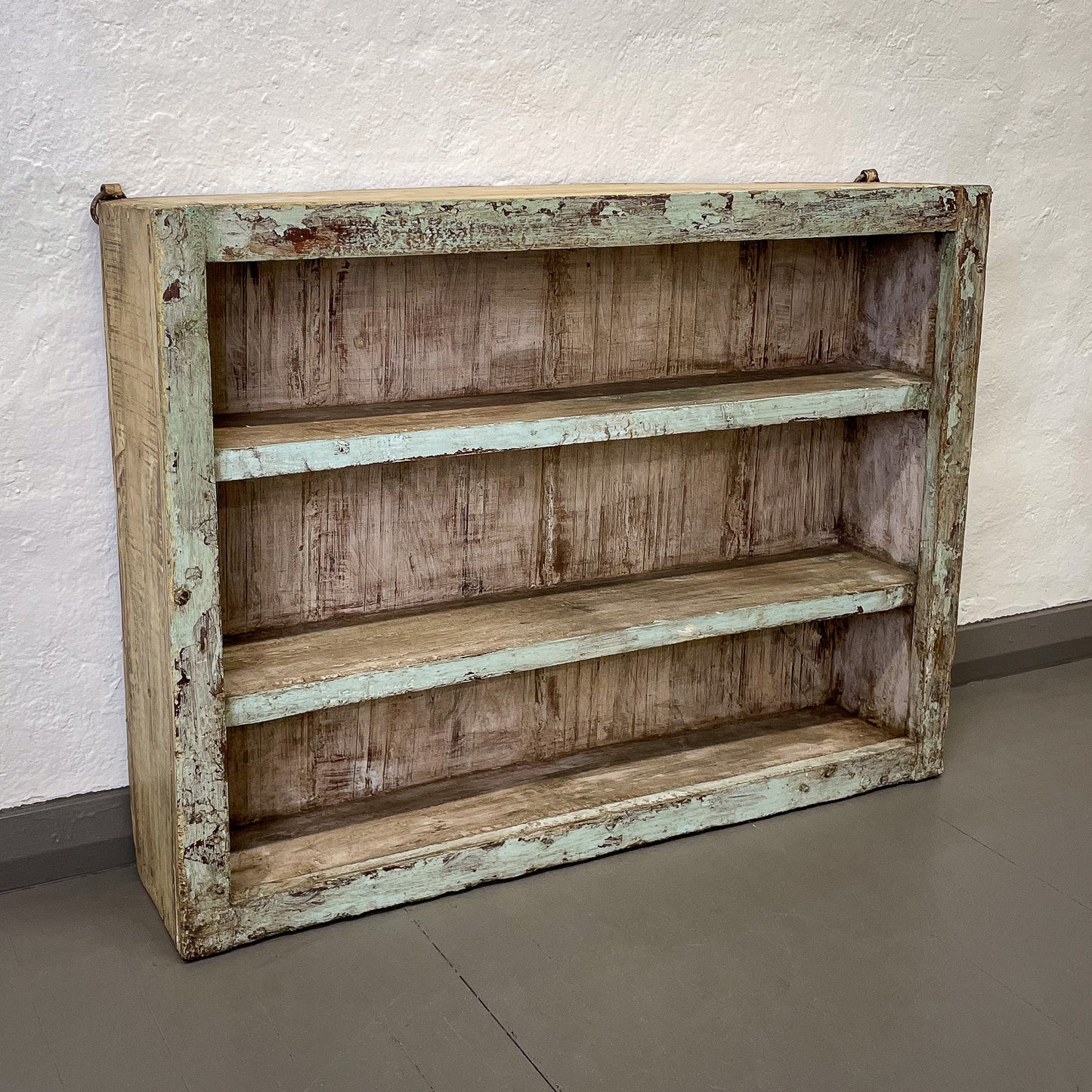 Rustic wooden shelf with weathered finish against a plain wall.