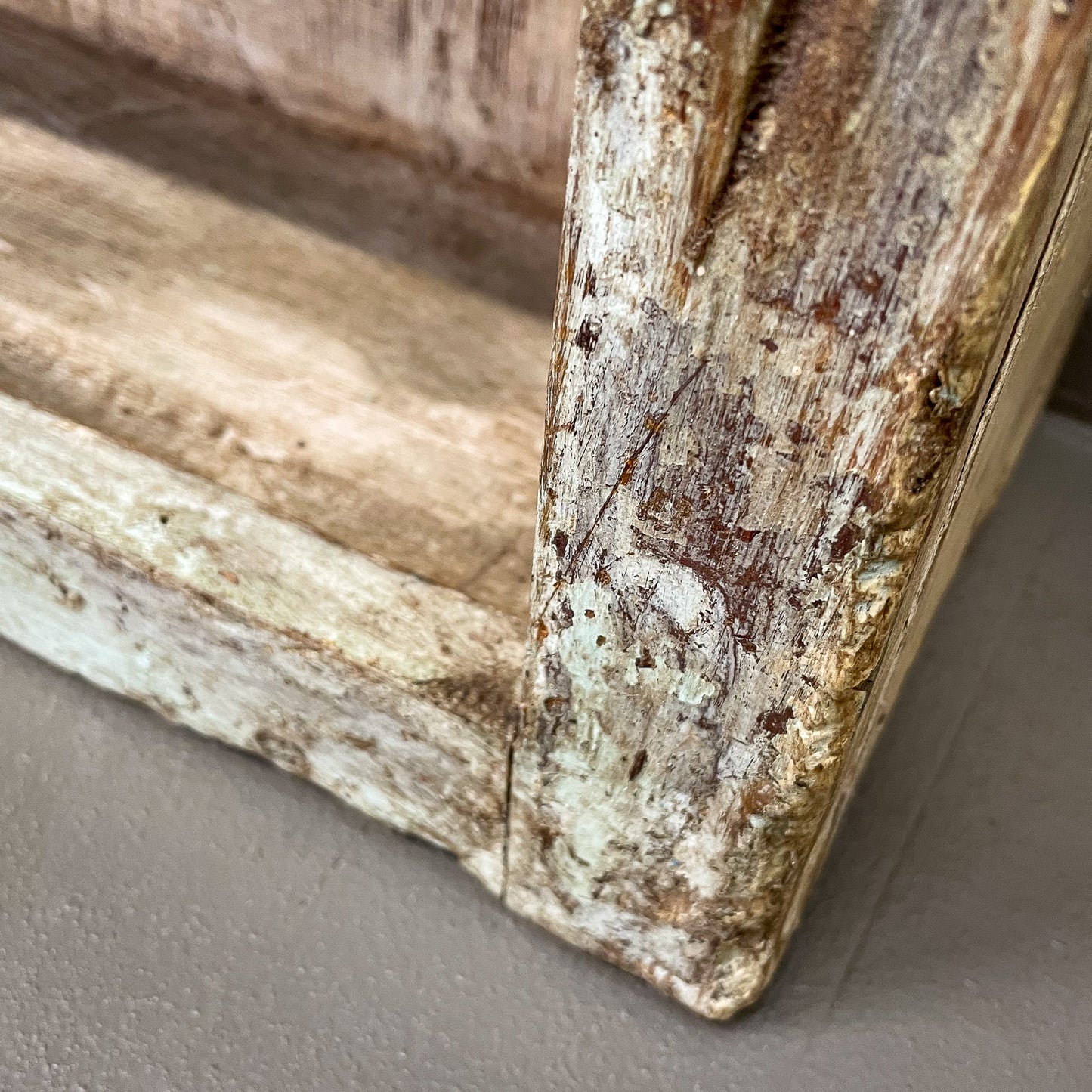 Close-up of a wooden frame with a rustic finish on a gray surface
