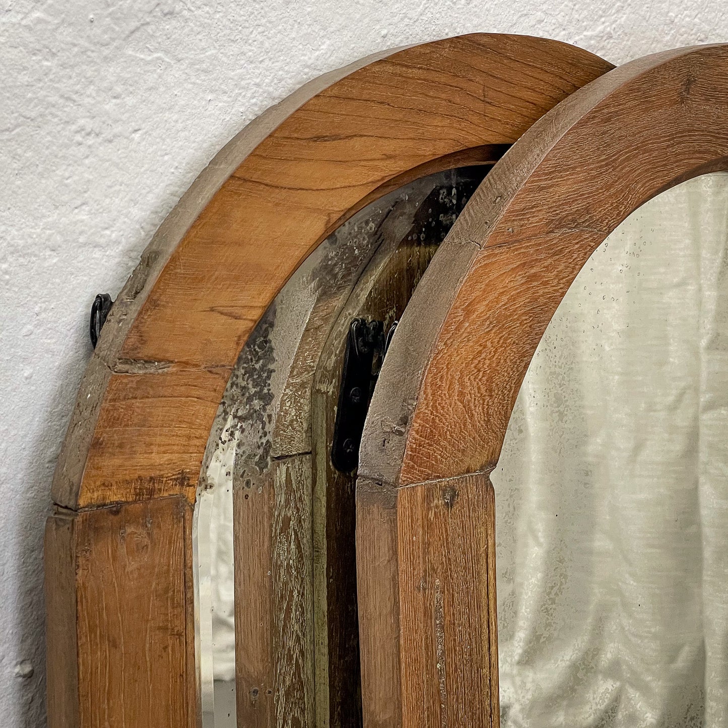 Close-up of wooden arches with a textured white wall background