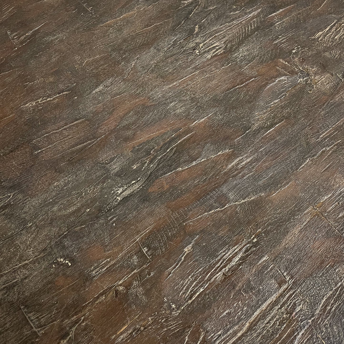 Close-up of a textured brown surface with visible wood grain.
