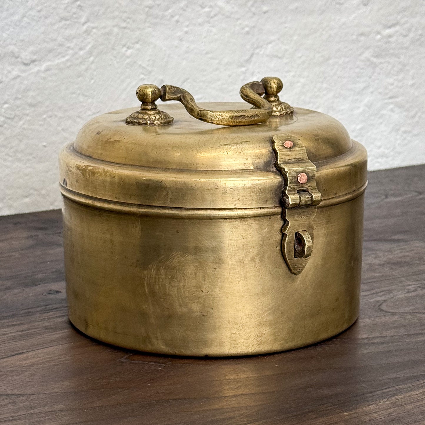 Brass box with a lid on a wooden surface