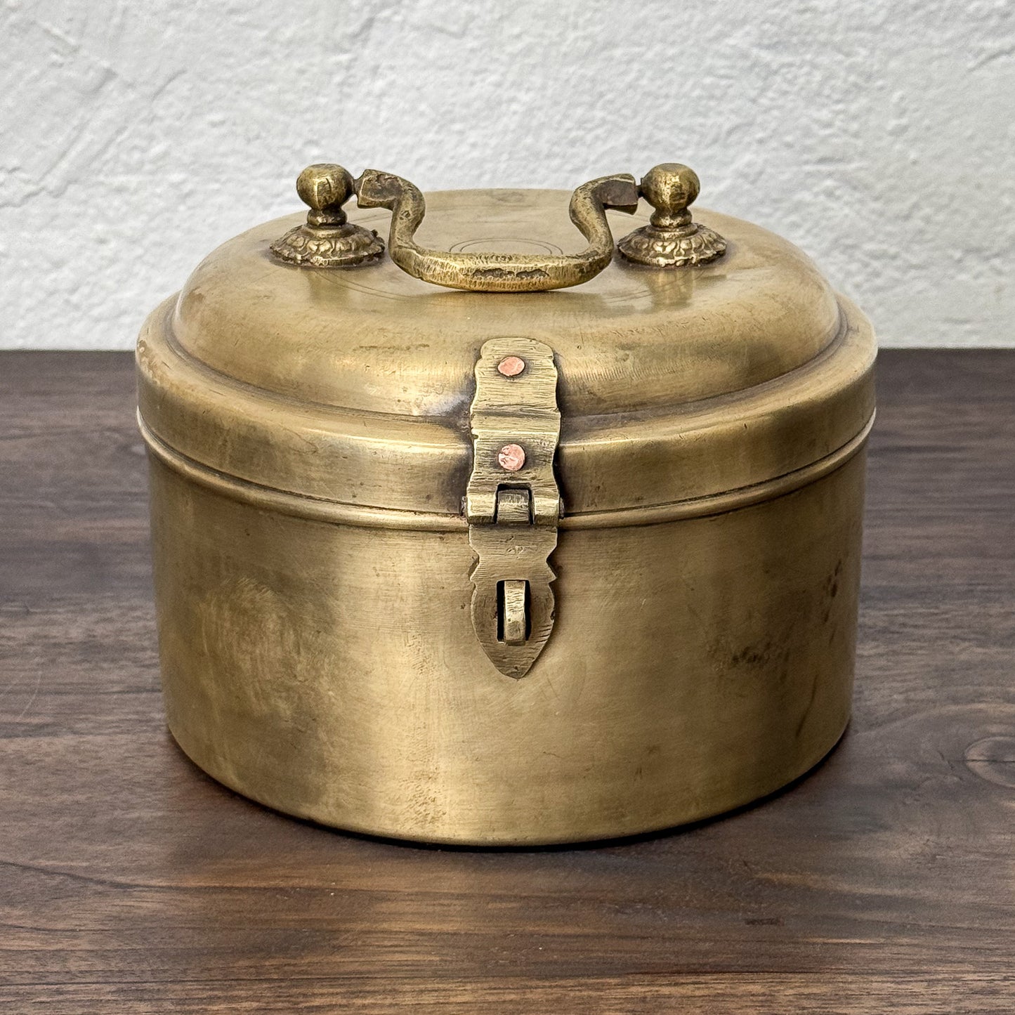 Brass box with a lid on a wooden surface