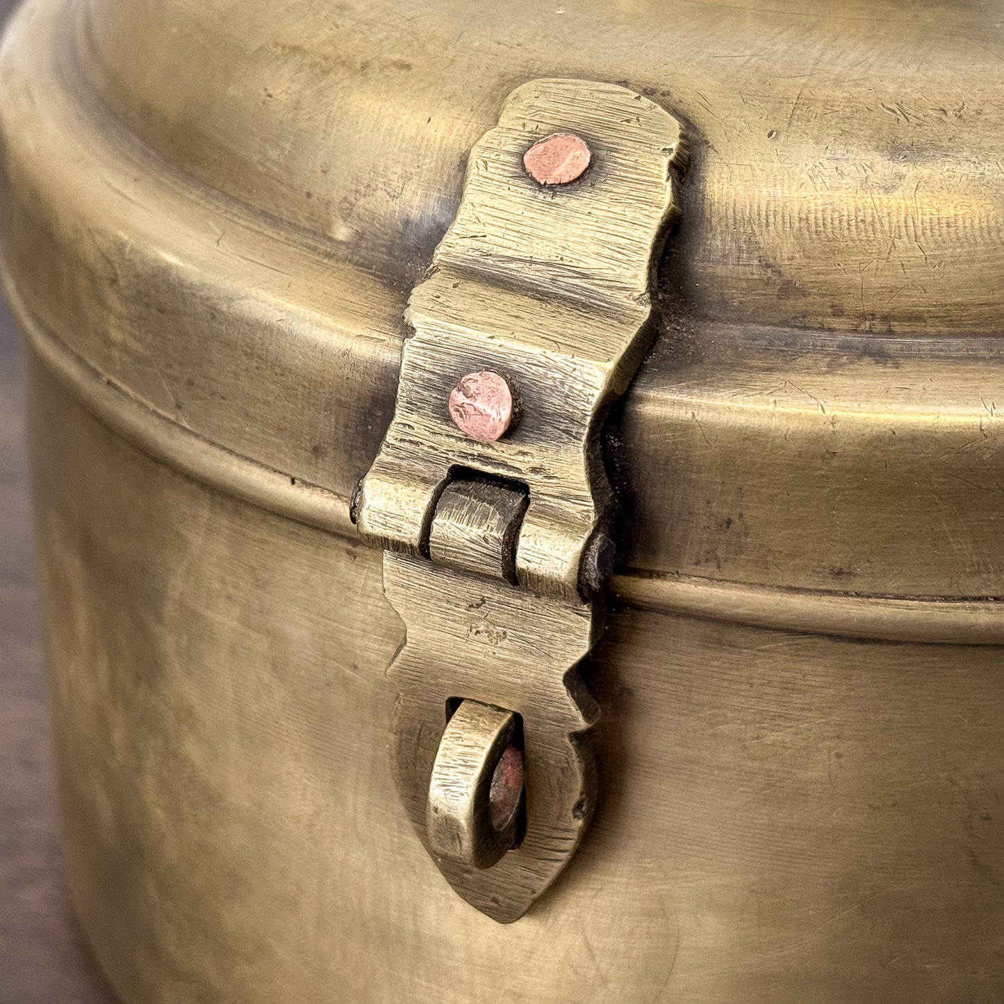 Close-up of a brass latch on a brass container