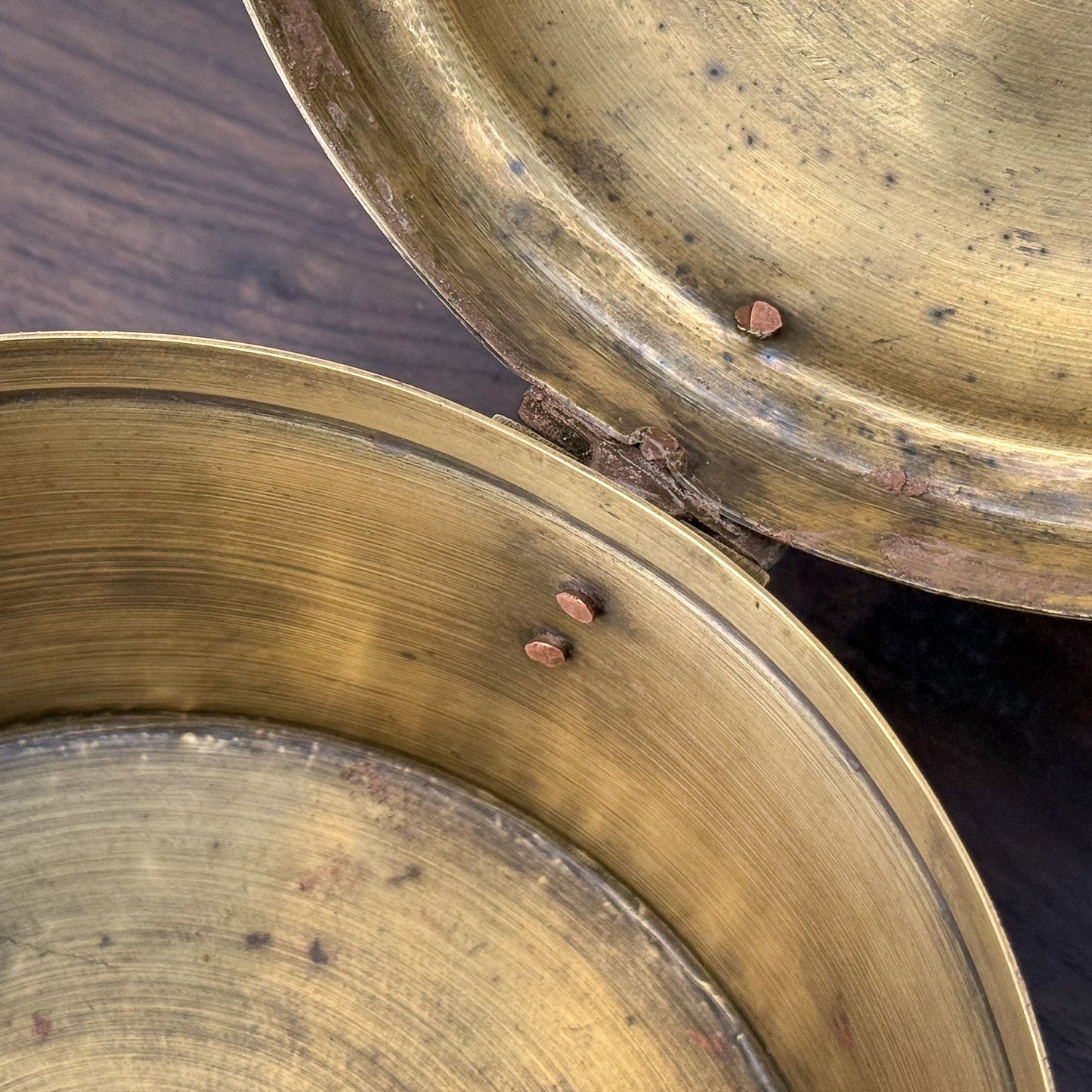 Close-up of two brass plates with a dark background