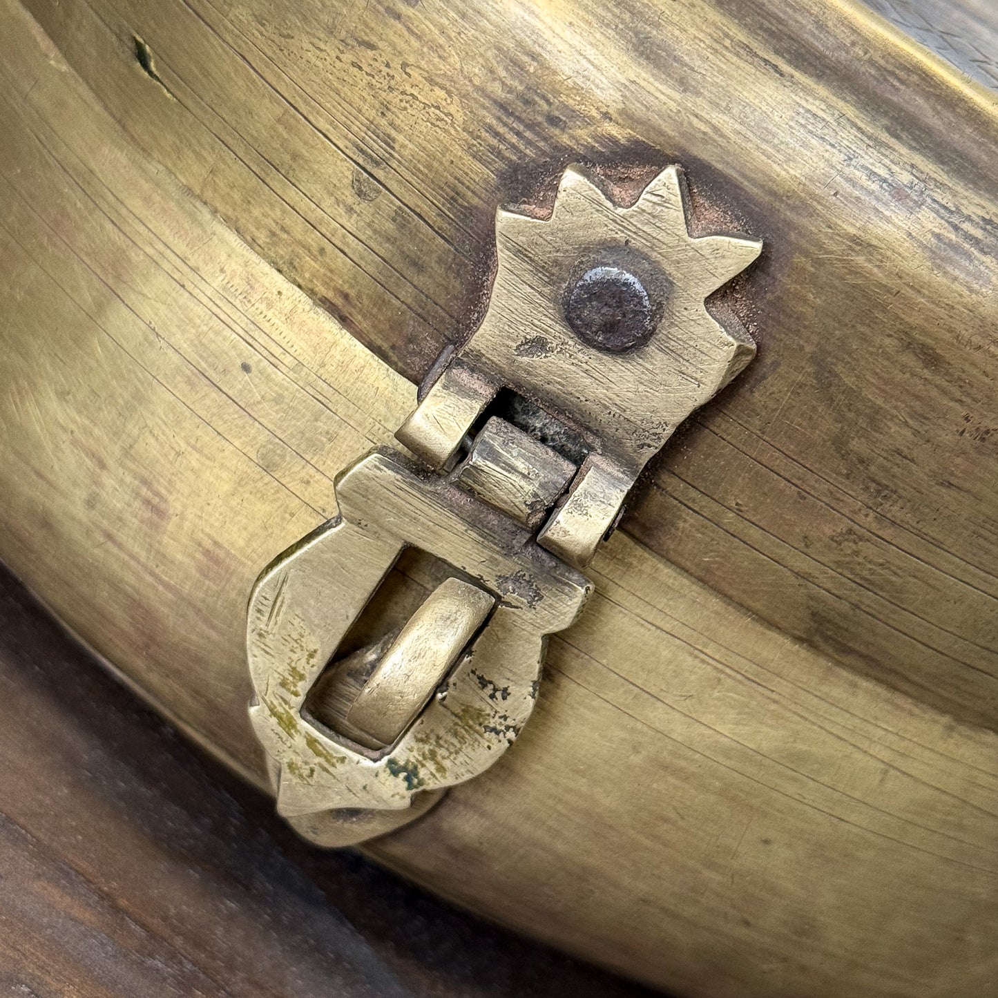 Close-up of a brass latch on a wooden surface